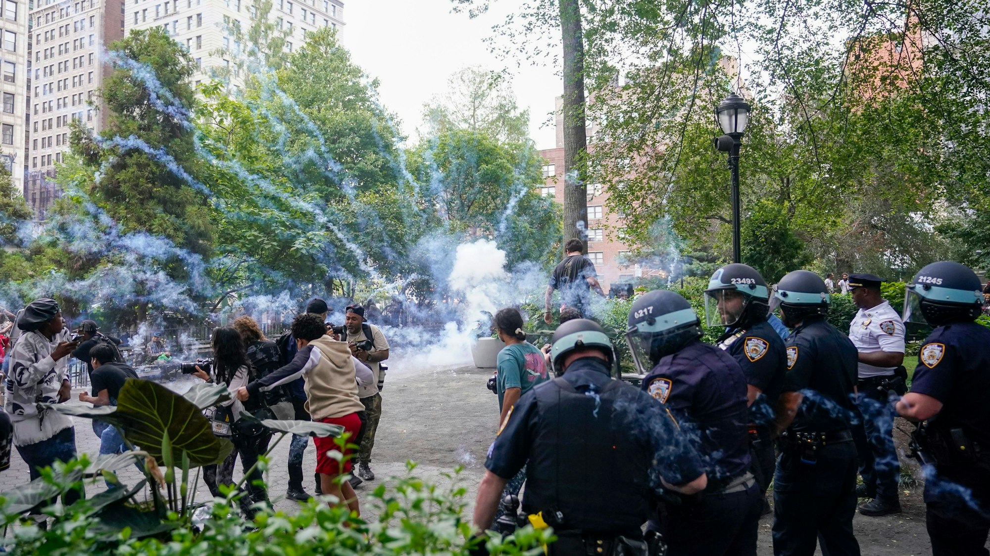 Polizeibeamte zünden eine Rauchbombe, um eine Menschenmenge auf dem Union Square zu zerstreuen.