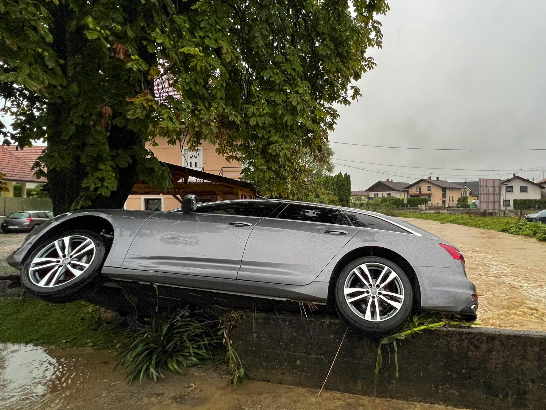 Ein Auto hängt an einer Brücke.