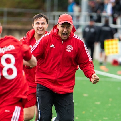 Das Bild zeigt den Zülpicher Trainer, der mit geballten Fäusten und aufgerissenem Mund auf seinen Spieler zuläuft.