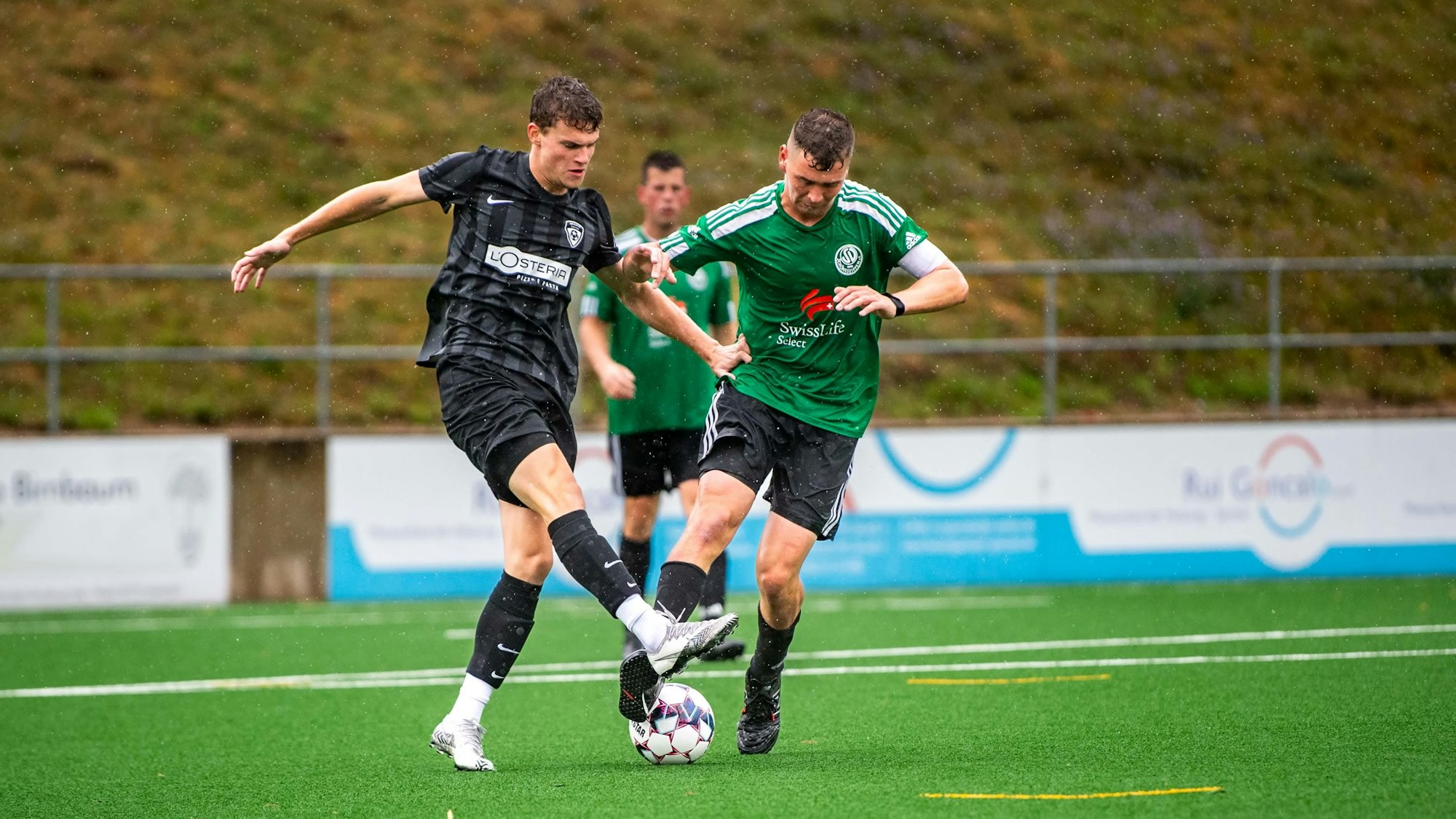 Das Bild zeigt zwei Fußballer im Zweikampf.