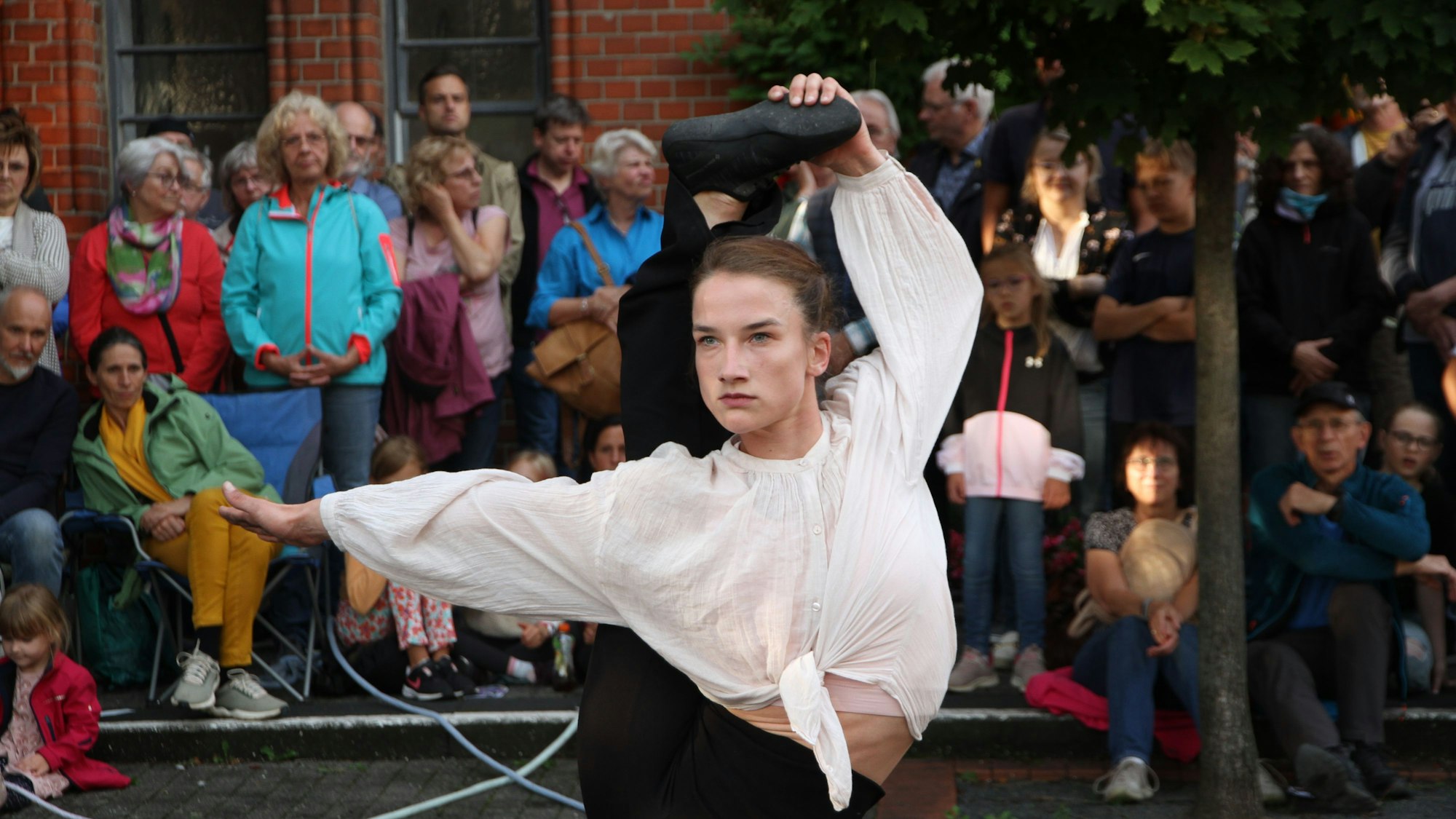 Eine Akrobatin biegt ihren rechten Fuß über den Kopf