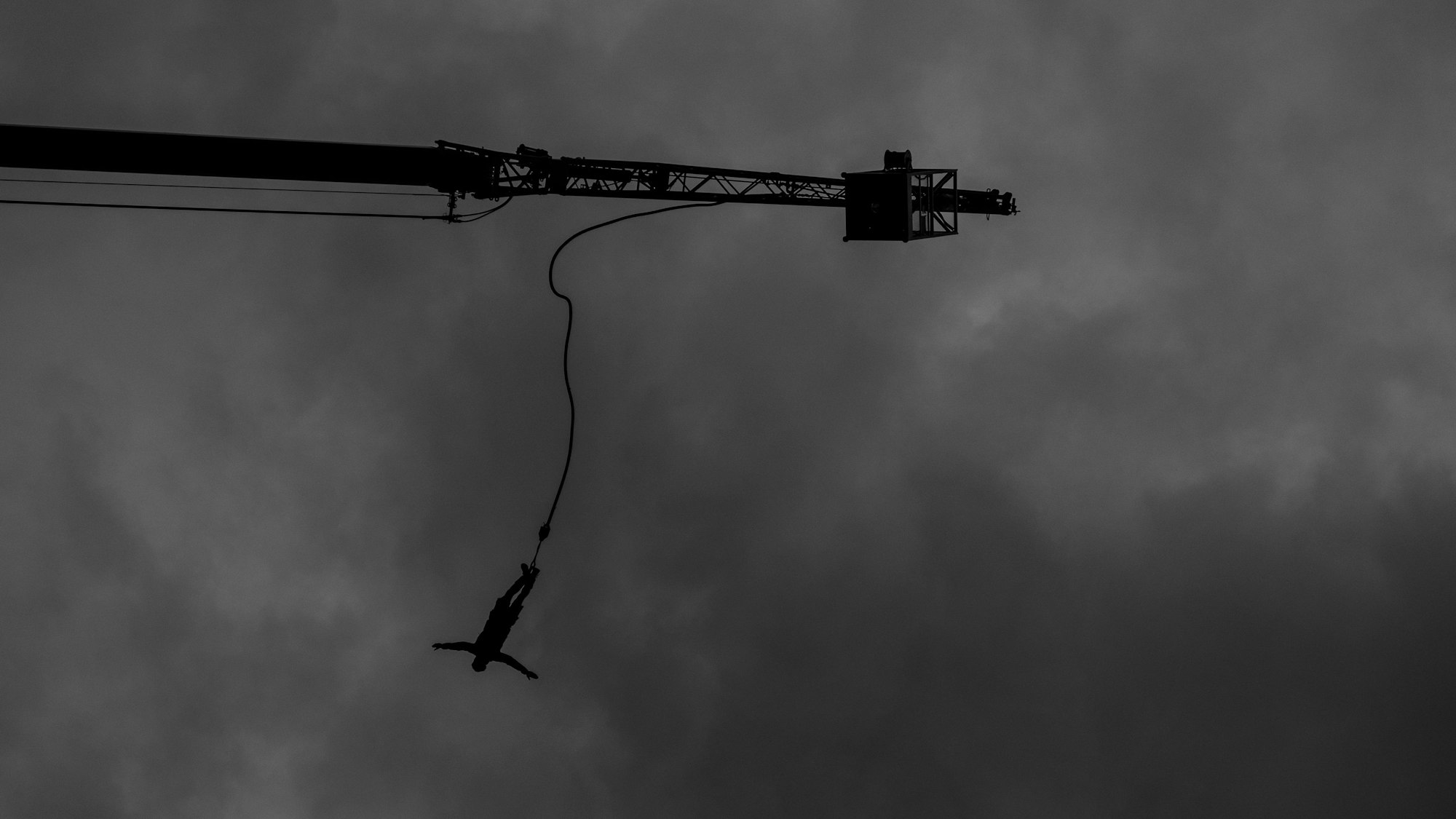 RECORD DATE NOT STATED A silhouette of a bungee jumper against a gloomy sky in grayscale *** einer Schattenriss des einer bungee Jumpen gegen einer d