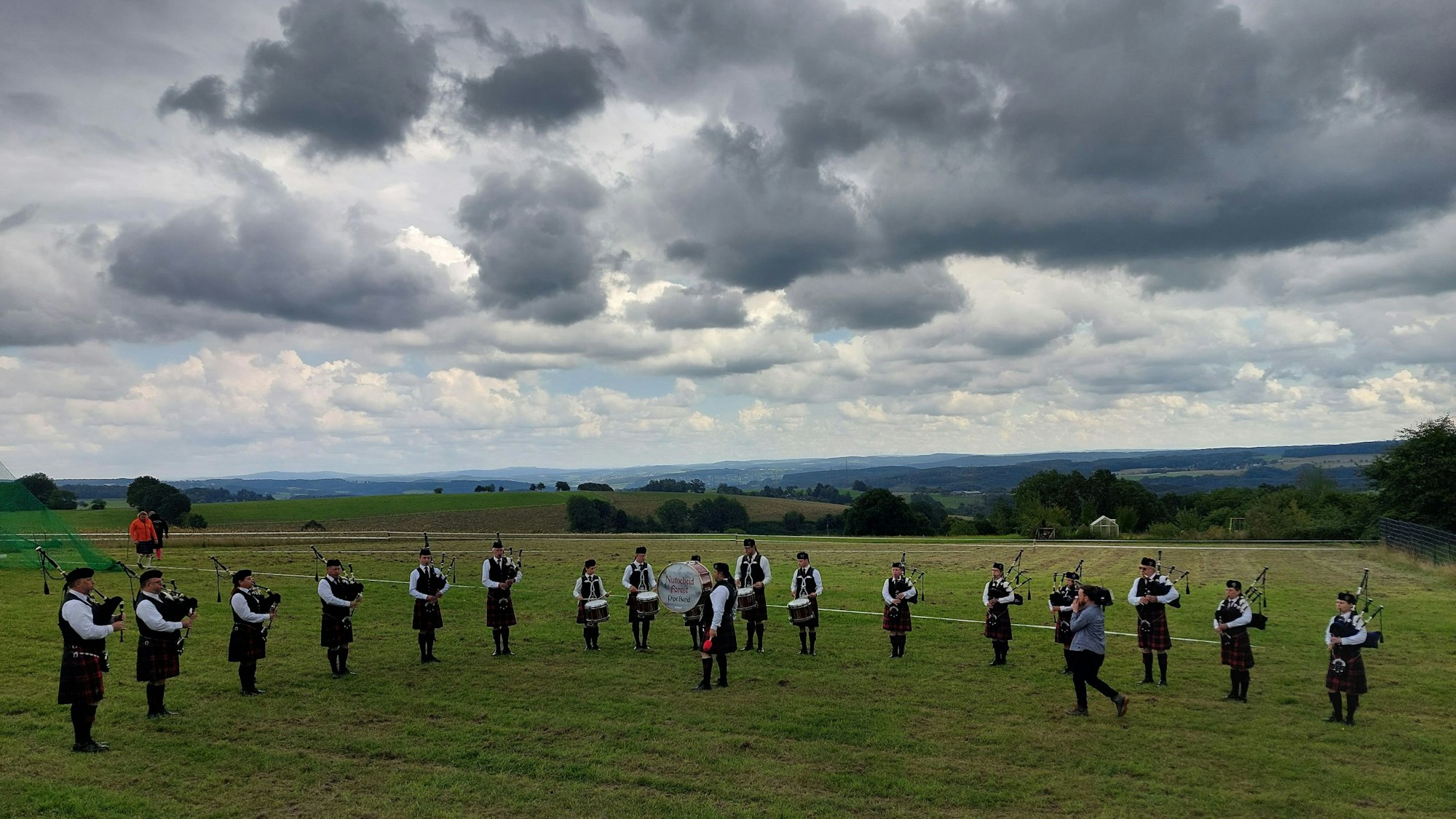 Dudelsackspieler auf einer Wiese.