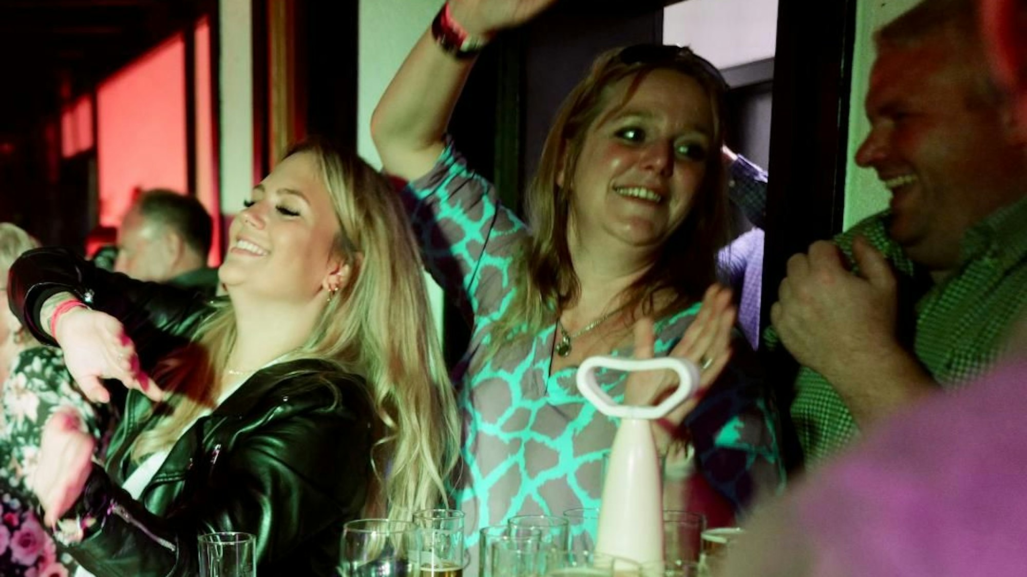 Zwei feiernde Frauen stehen an einem Biertisch.
