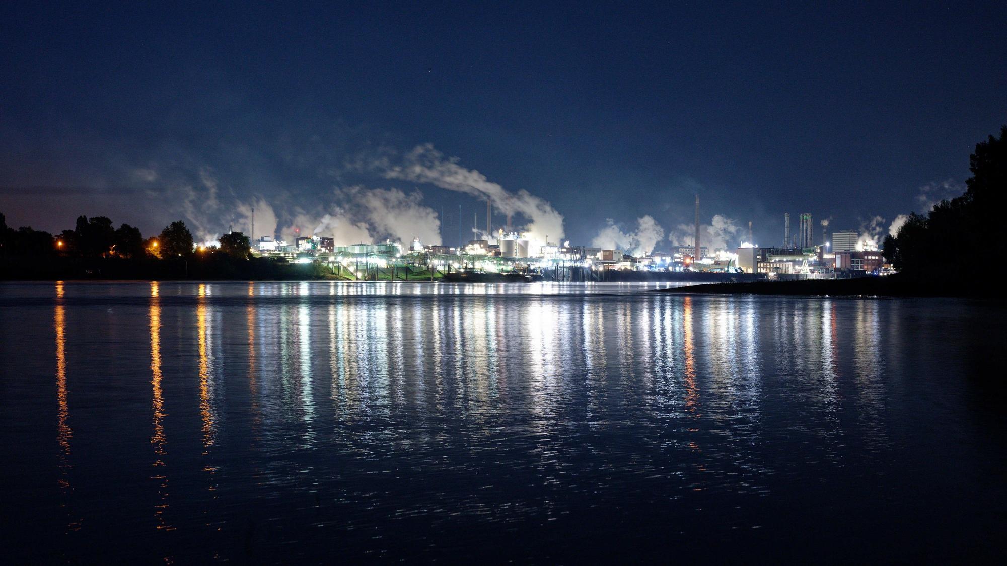 Leverkusen: Die Lichter des Chemparks in Leverkusen spiegeln sich im Wasser des Rheins.