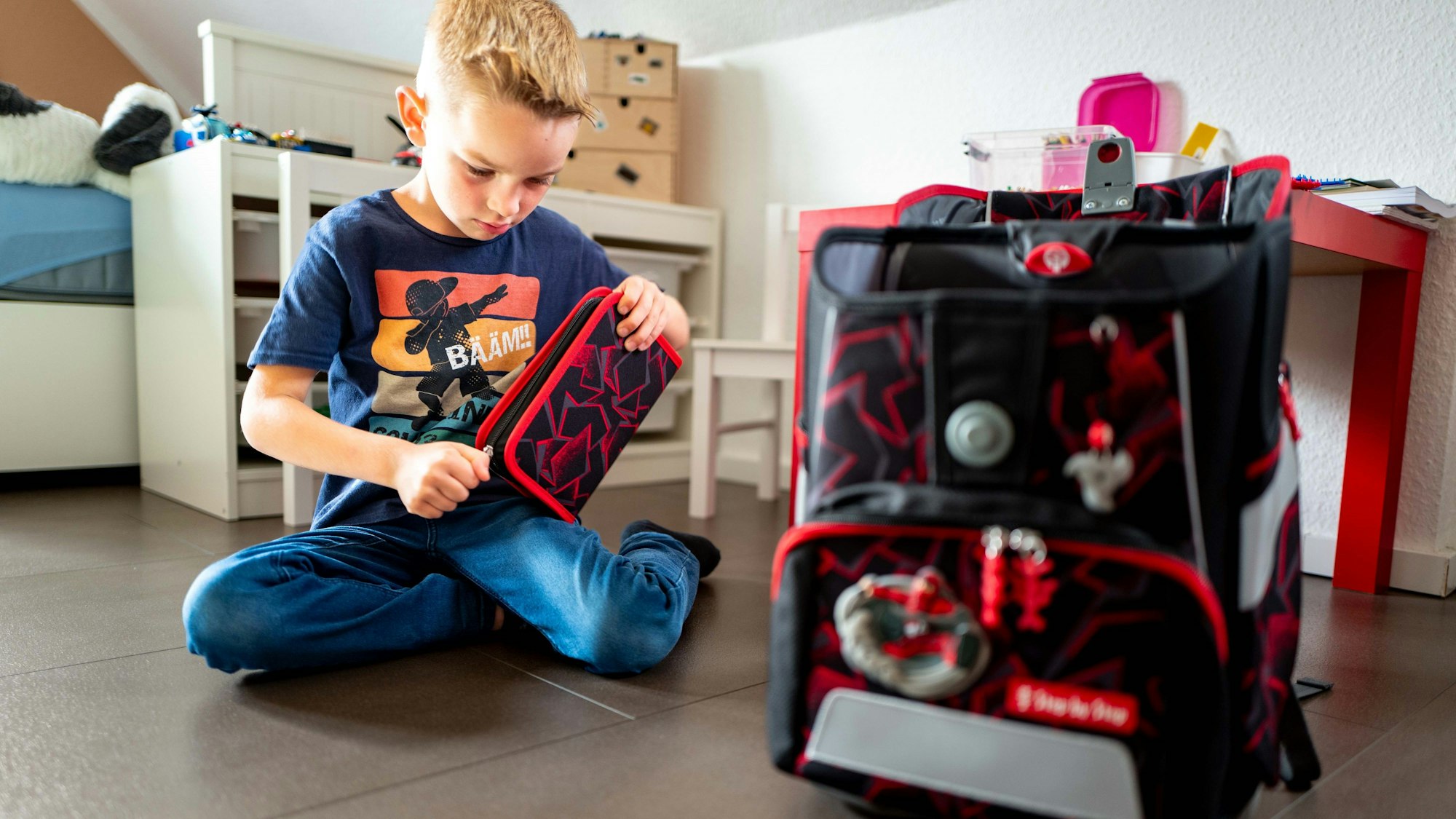 Das Bild zeigt den jungen Zülpicher, wie er vor einem Jahr seinen Schulranzen packt.