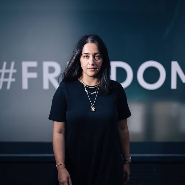 Elmira Rafizadeh vor einem mit der Aufschrift „Freedom“ beklebten Fenster.