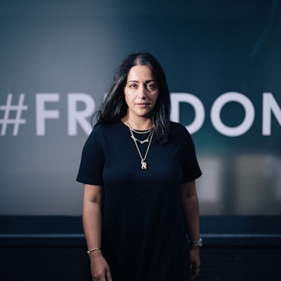 Elmira Rafizadeh vor einem mit der Aufschrift „Freedom“ beklebten Fenster.