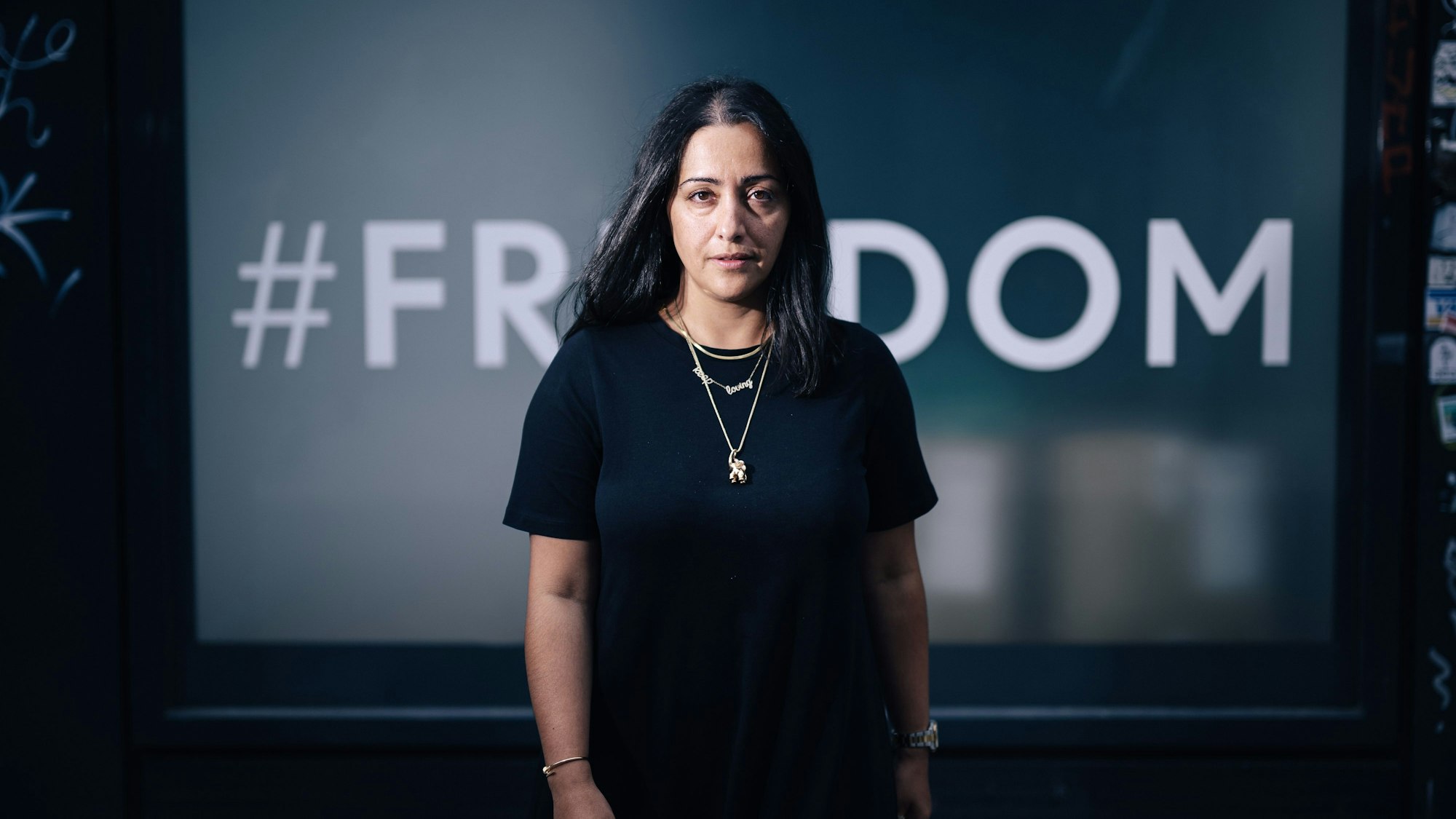 Elmira Rafizadeh vor einem mit der Aufschrift „Freedom“ beklebten Fenster.