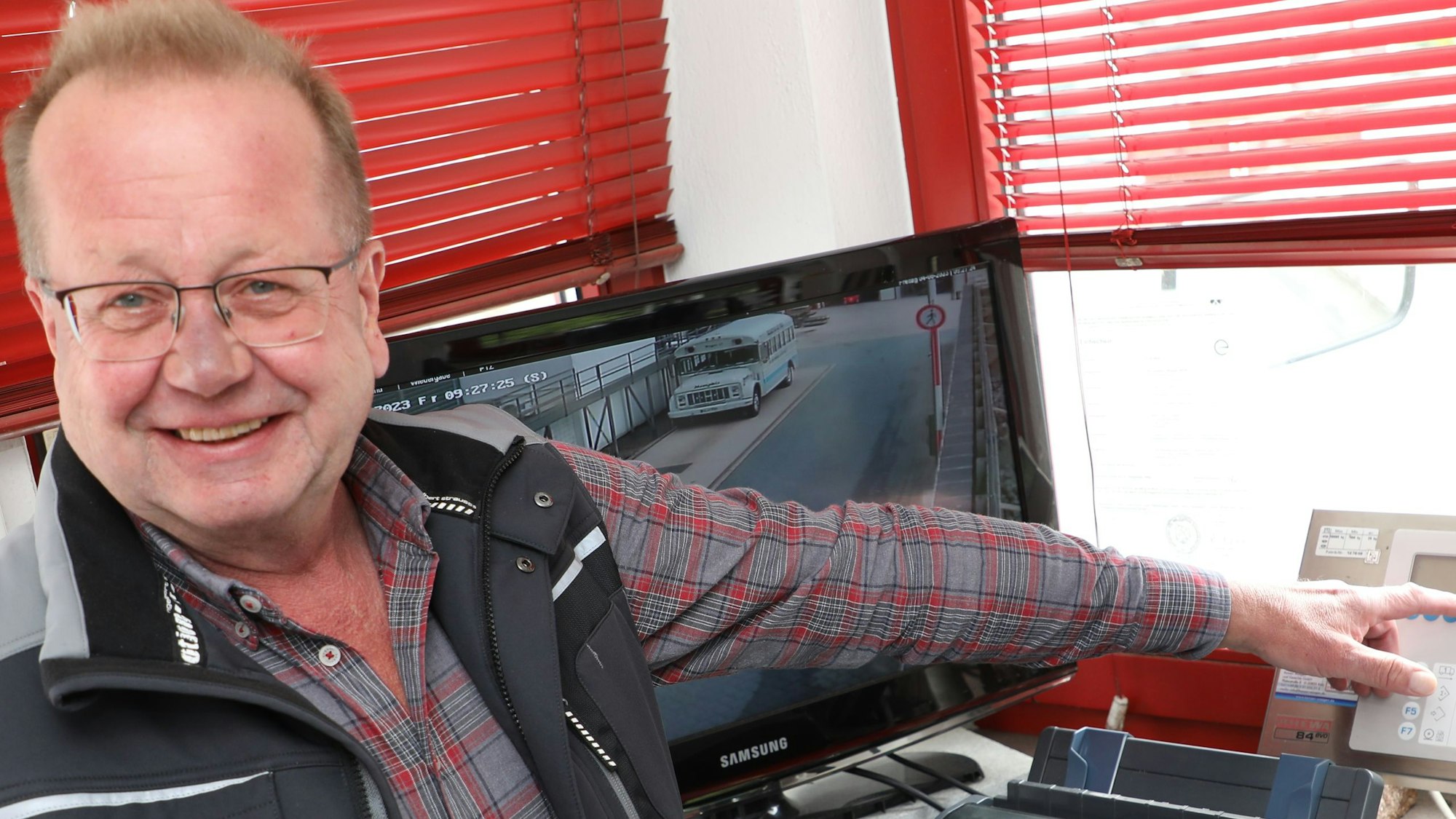 Helmut Spanier zeigt auf die Anzeige der Lkw-Waage der Firma Metten.