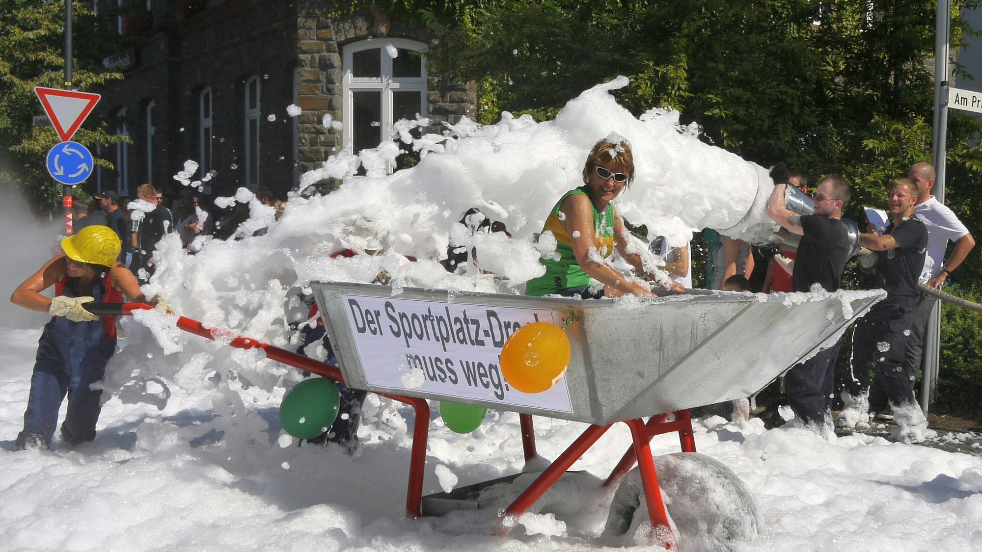 Eine überdimensionale Schubkarre rollt während des Schubkarrenrennens in Morsbach am Rathaus der Gemeinde vorbei.
