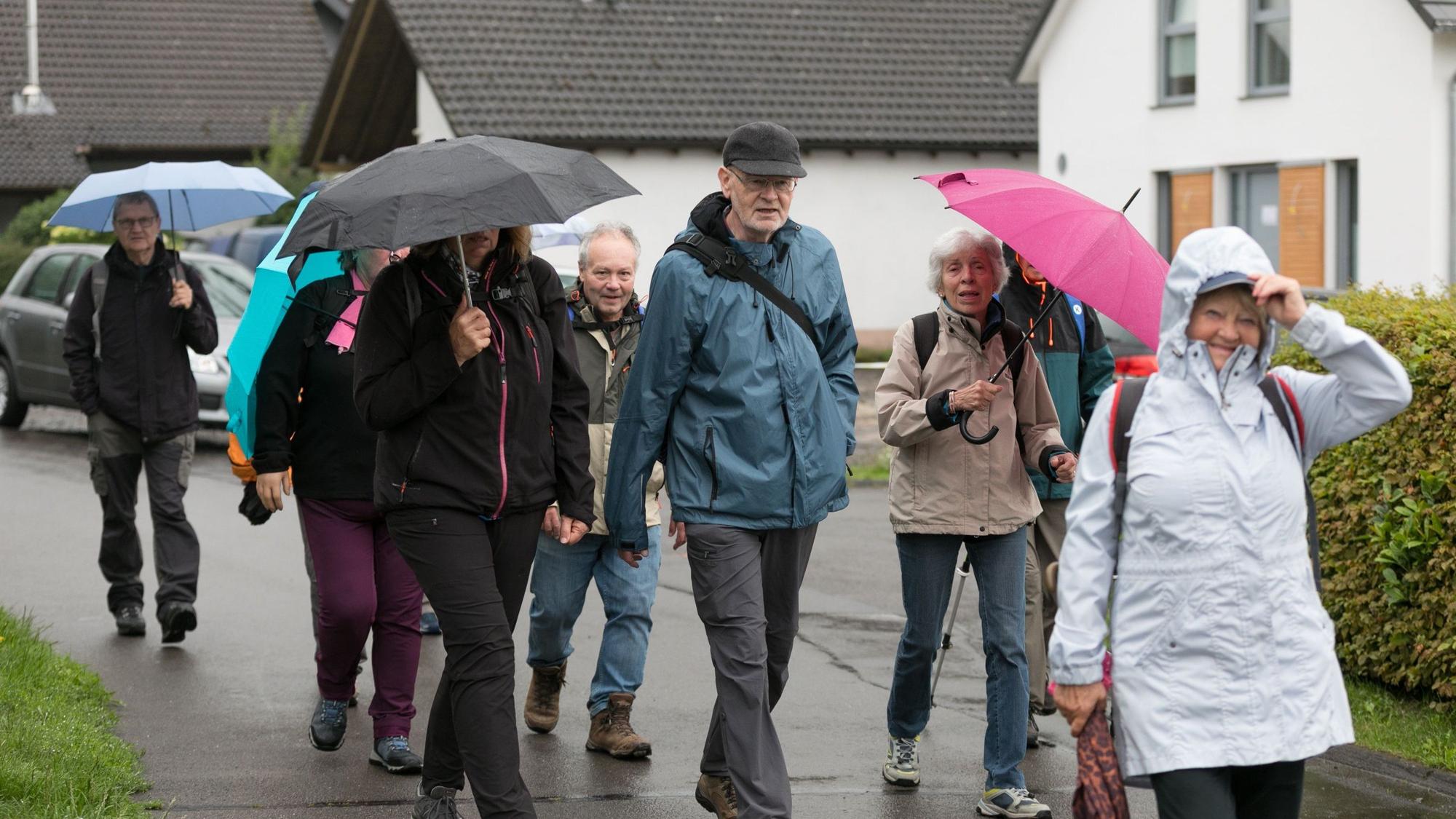 Mit Regenschirm und Regenjacken ausgerüstet trotzen die Wanderfreunde dem Regen.