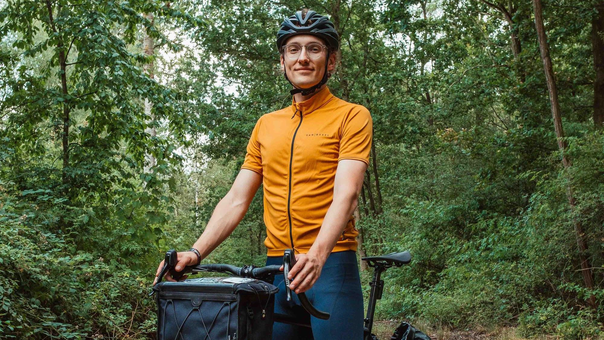 Ein junger Mann sitzt auf einem Fahrrad mit Packtaschen