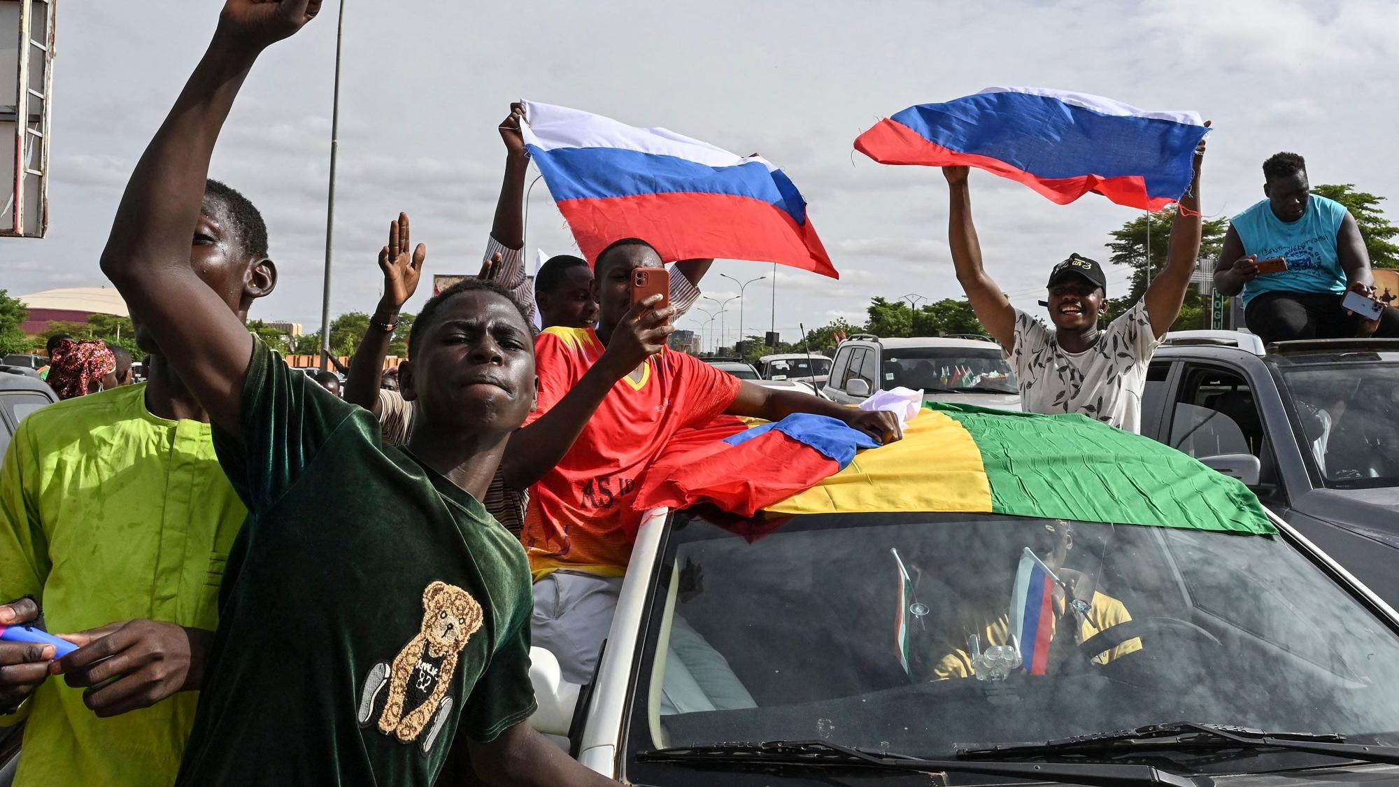 Menschen in Niger halten bei einer Demosntration russische Flaggen in die Luft.