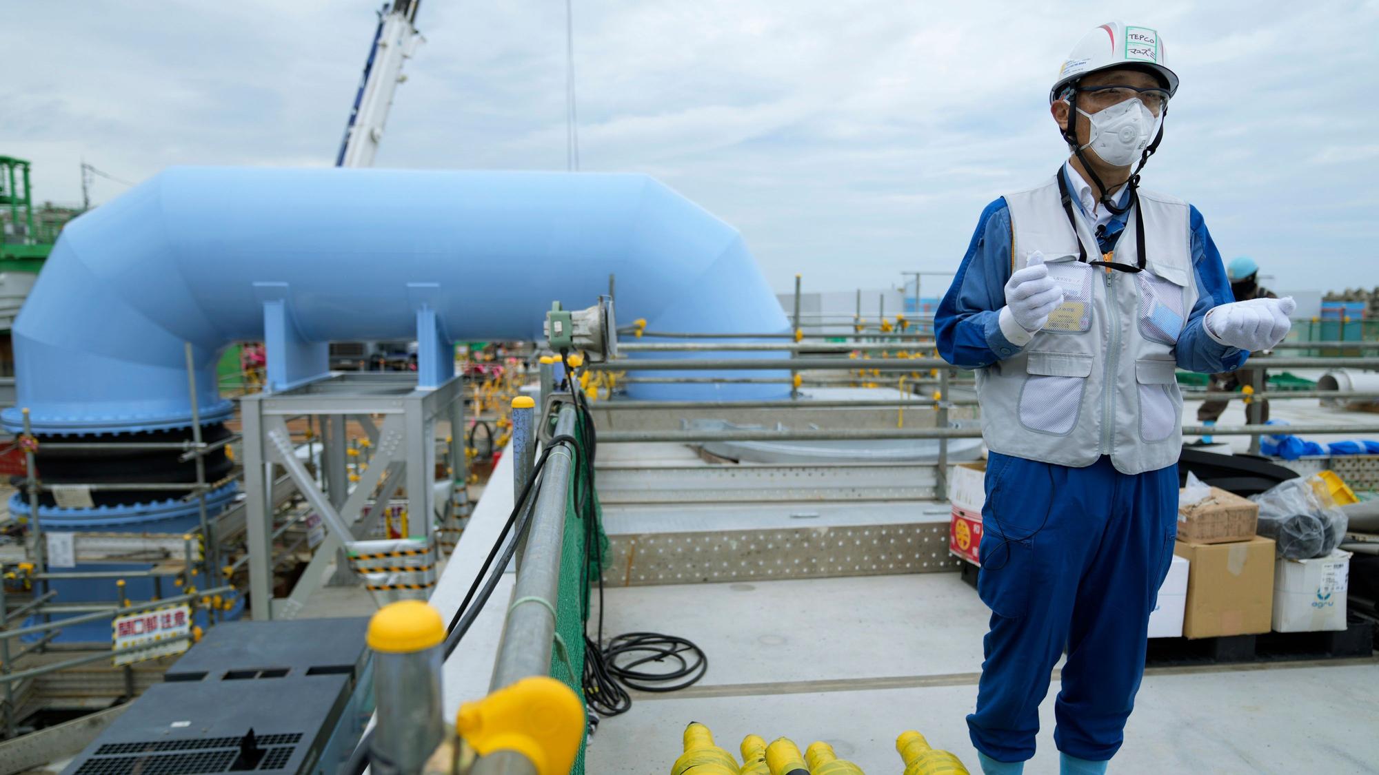 Ein Sprecher von Tokyo Electric Power Company Holdings (TEPCO), spricht während einer Führung durch das Kernkraftwerk Fukushima Daiichi über die geplante Ablassung des aufbereiteten Kühlwassers ins Meer.