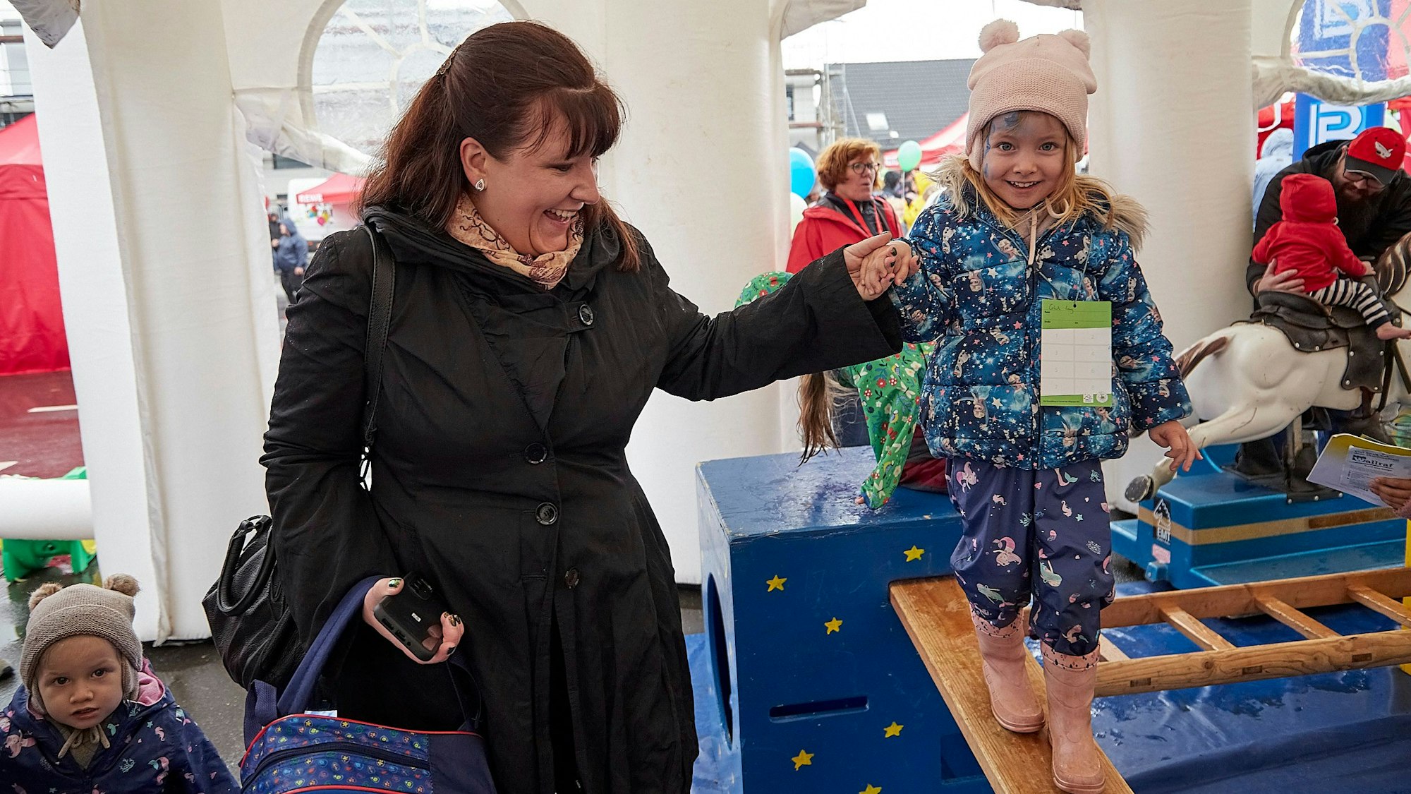 Mutter Jasmin Lang hält die Hand ihrer balancierenden Tochter Celeste.