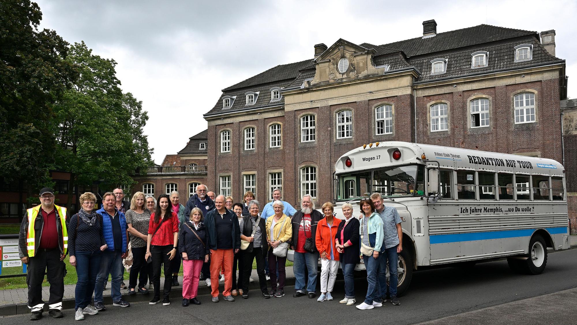 Menschen stehen vor einem historischen amerikanischen Schulbus.