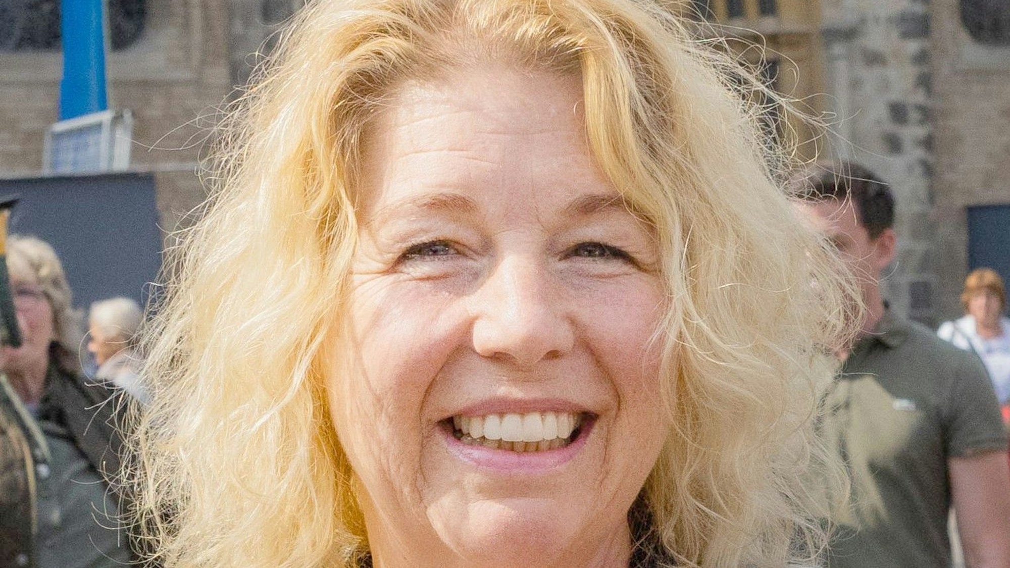 Eine Frau mit blonden Haaren lächelt in die Kamera.