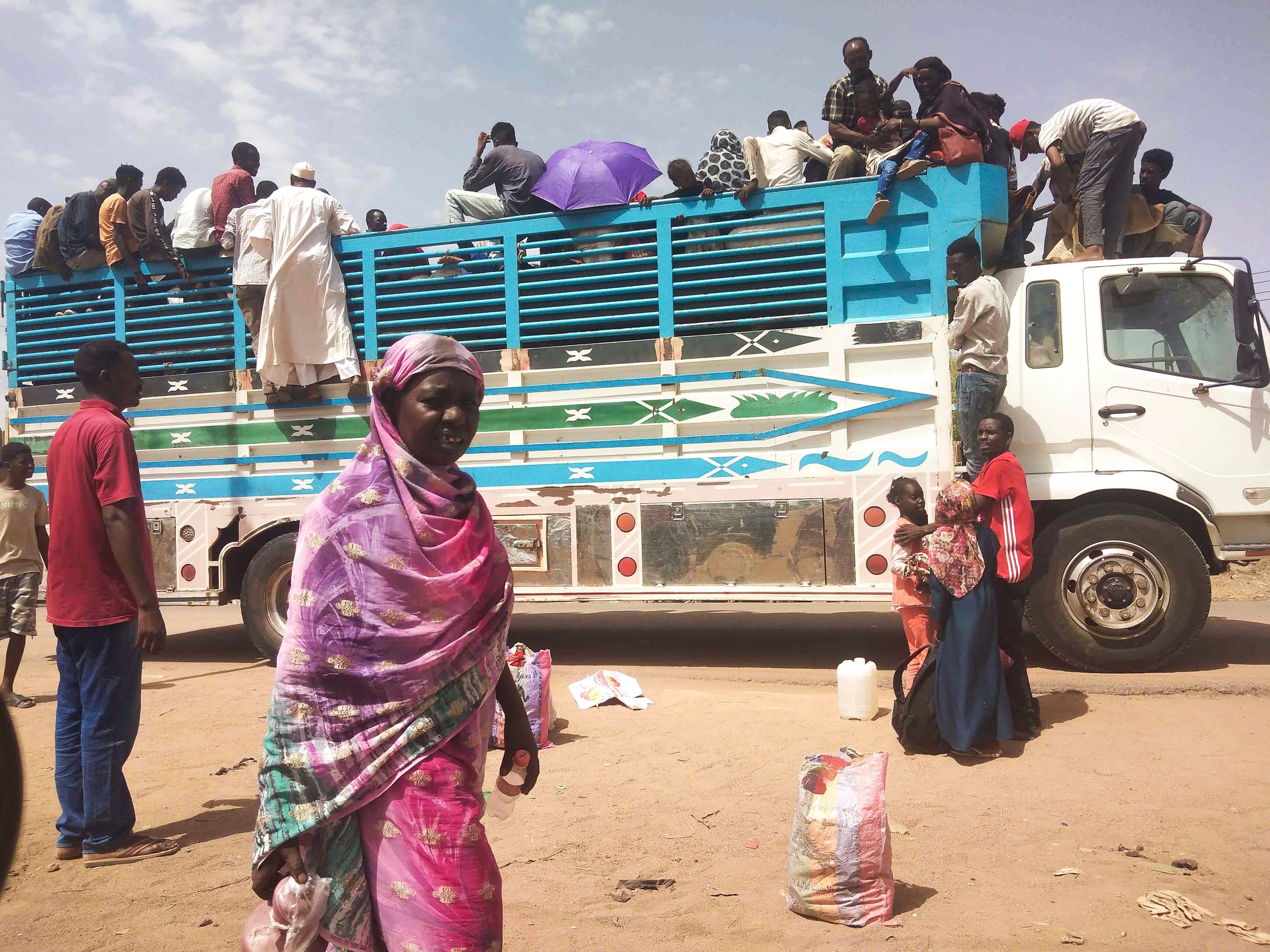 Sudan, Khartum: Menschen besteigen einen Lastwagen, um die Stadt zu verlassen.