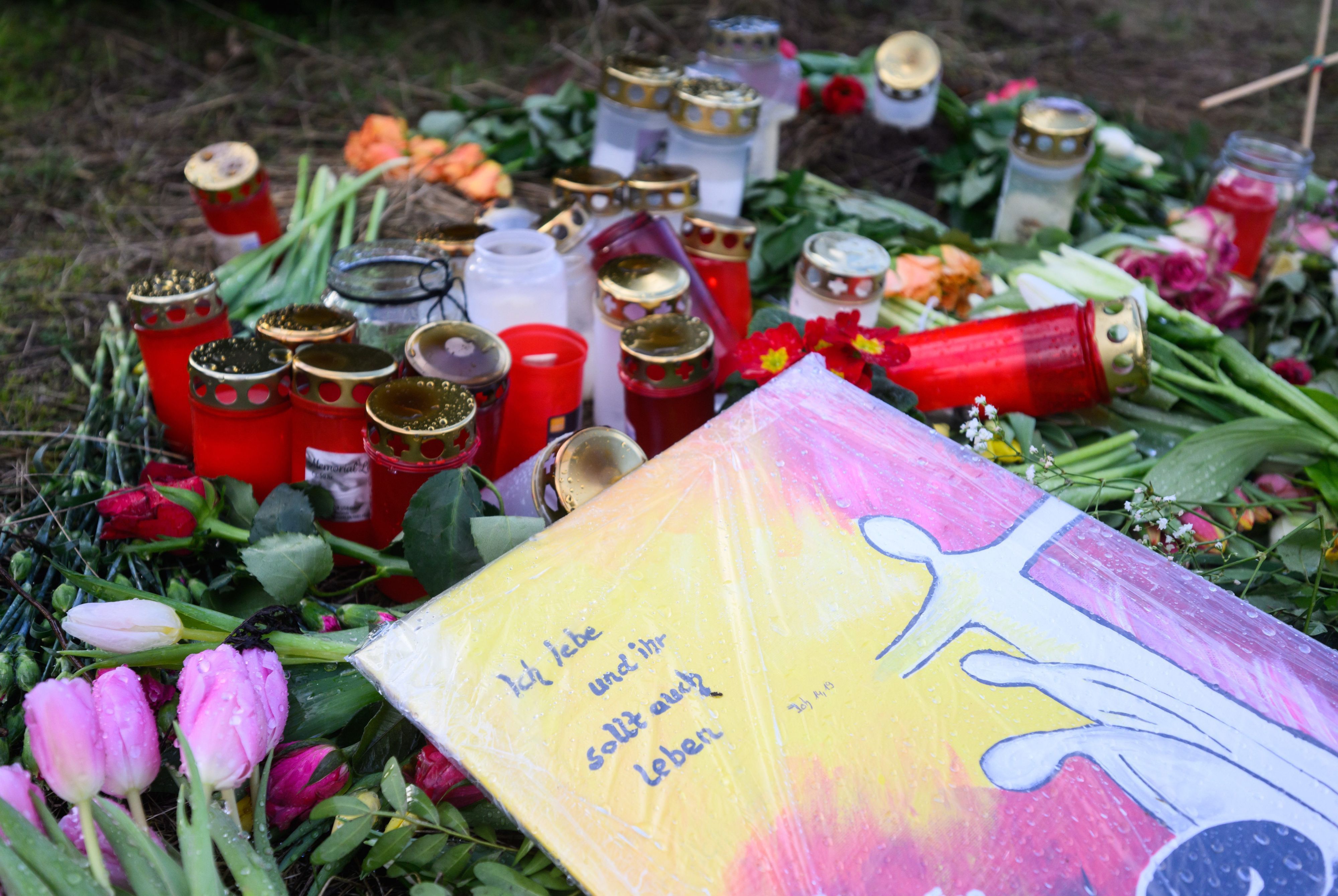 Wunstorf in Niedersachsen: Kerzen, Blumen und eine Tafel liegen an einem Brachgelände, wo ein 14-Jähriger einen Gleichaltrigen getötet haben soll.