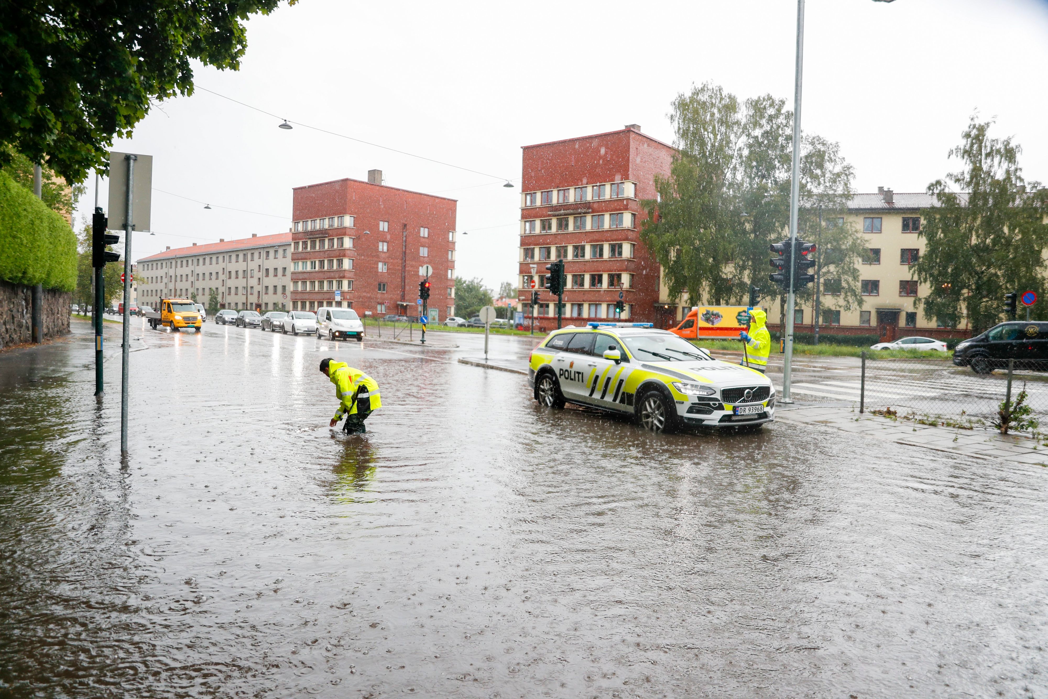 Oslo: Polizisten öffnen die Abwasserkanäle auf Straßen während eines aufziehenden Unwetters, das in Skandinavien zu Überschwemmungen, Bränden und Wasserschäden geführt hat