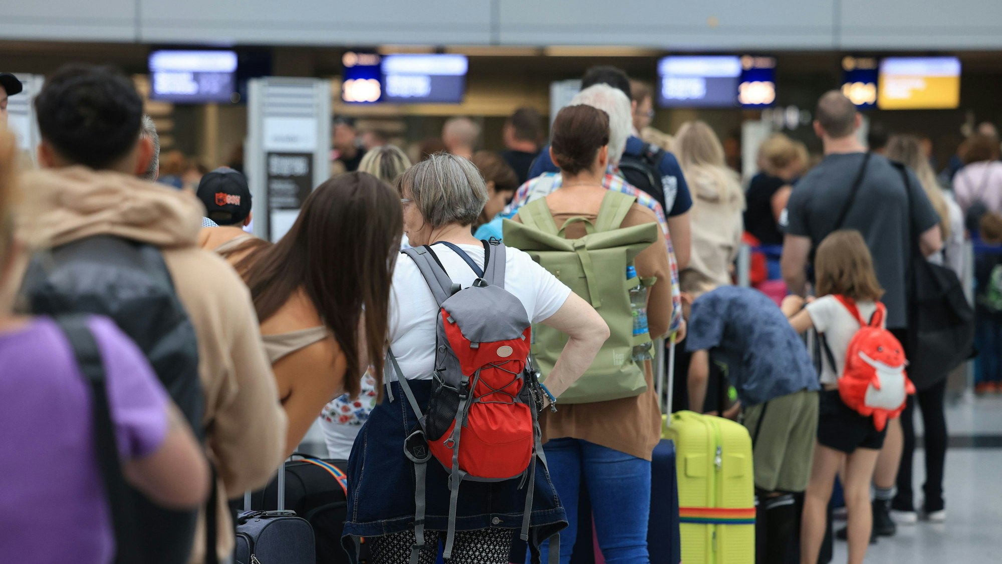 Reisende stehen am Flughafen Düsseldorf in einer Warteschlange. An deutschen Flughäfen läuft der Flugverkehr im Sommer 2023 stabiler als im chaotischen Vorjahr. (Symbolbild)