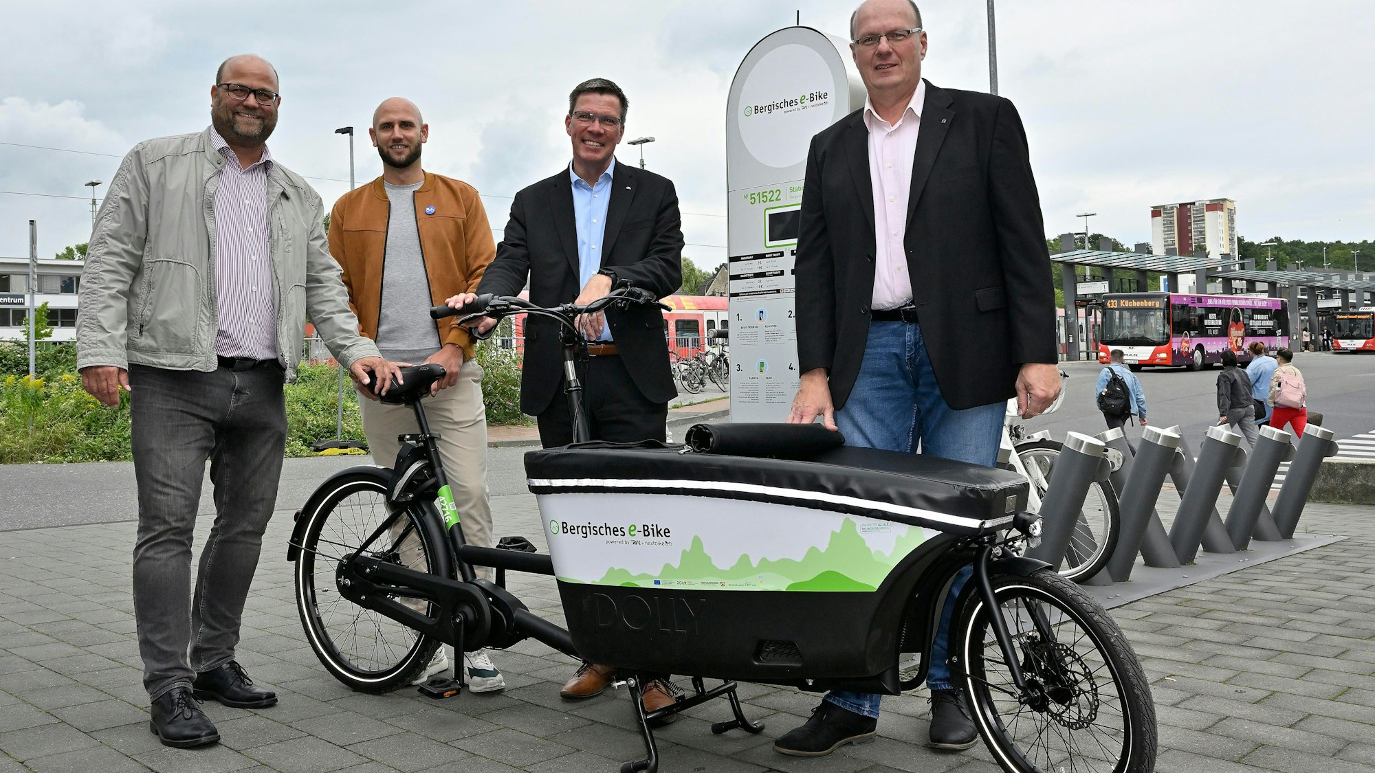 Vier Männer präsentieren ein neues E-Lastenrad am Bergisch Gladbacher S-Bahnhof.