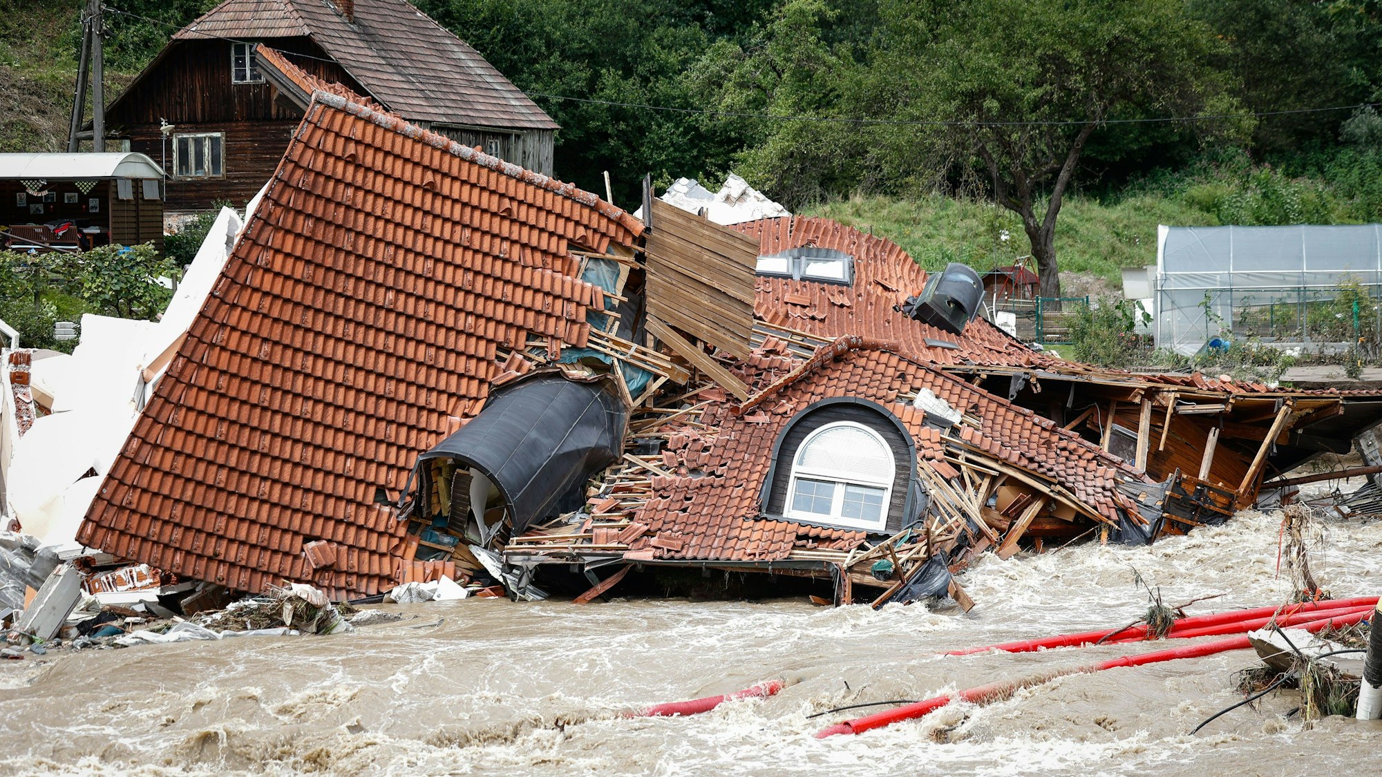 07.08.2023, Slowenien, Schwarzenbach: Ein zusammengestürztes Haus liegt in den Fluten. Die verheerenden Überschwemmungen im EU-Land Slowenien haben internationale Hilfe auf den Plan gerufen. Foto: Anze Malovrh/STA/dpa +++ dpa-Bildfunk +++
