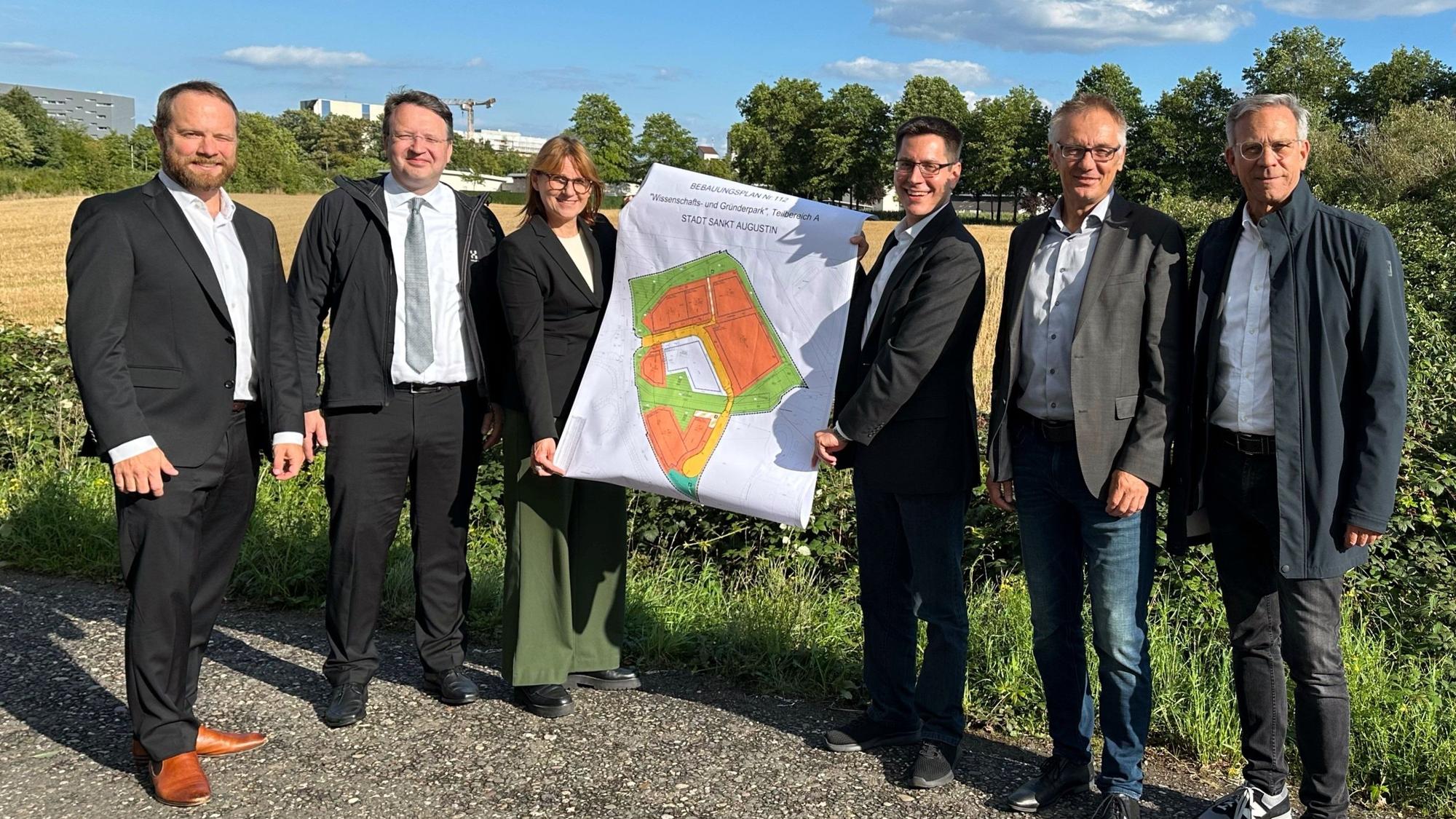 Michael Langerbeins, Prof. Dr. Frank Köster, Dr. Melanie von der Wiesche, Bürgermeister Dr. Max Leitterstorf, der Technische Beigeordnete Rainer Gleß und der Fachbereichsleiter Planung und Liegenschaften Uwe Trübenbach (v.l.) präsentieren am Butterberg den aktuellen B-Plan-Entwurf.
DLR