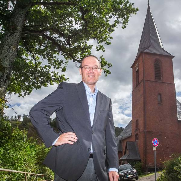 Pfarrer Marc Platten steht vor der Kirche der Emmaus-Kirchengemeinde in Wiedenest-Derschlag.