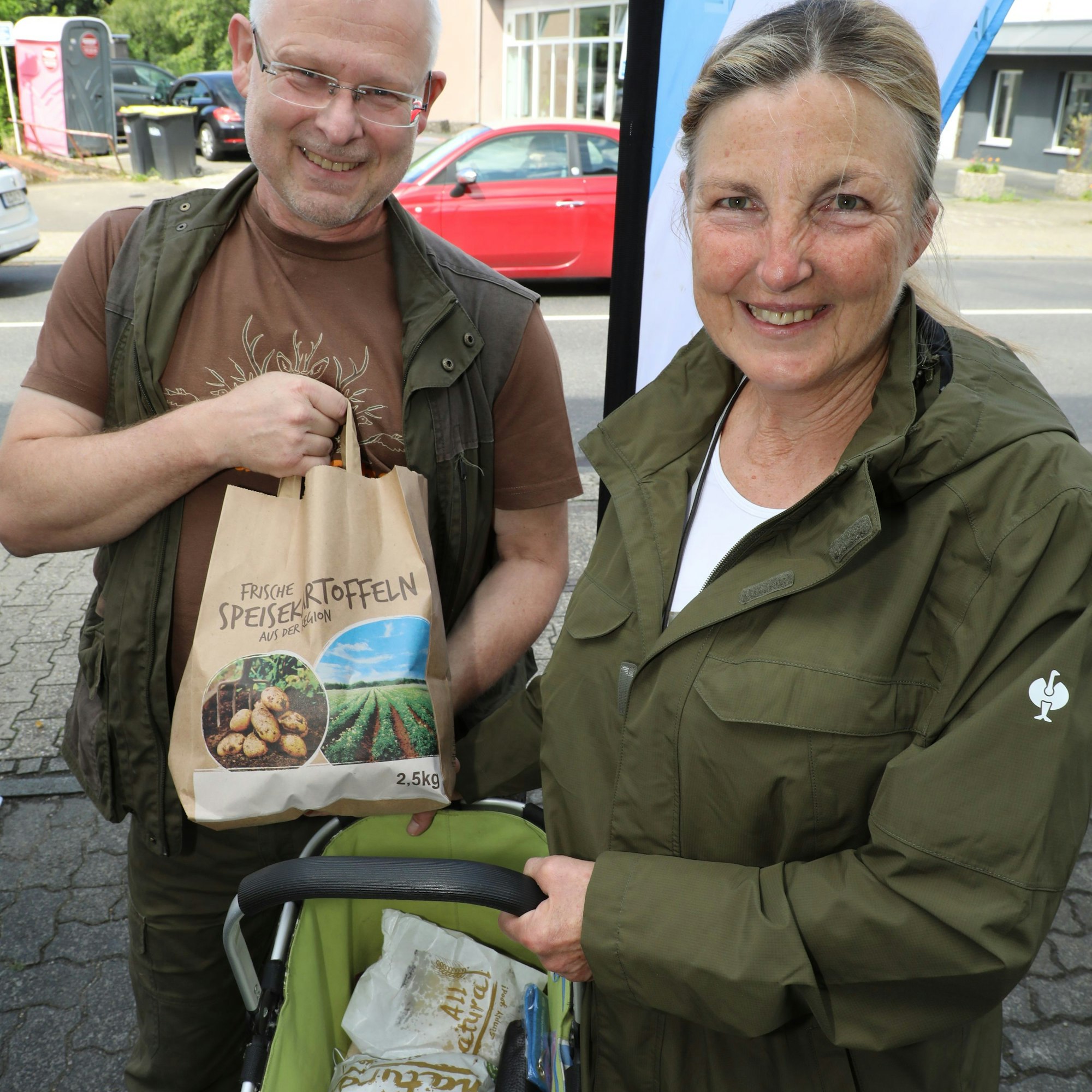 Gabi Pollerhoff und Ralf Huckriede zeigen die regionalen Produkte, die sie auf dem Hoffnungsthaler Wochenmarkt eingekauft haben.