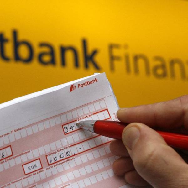 ILLUSTRATION - Ein Postbankkunde füllt einen Überweisungsträger aus.