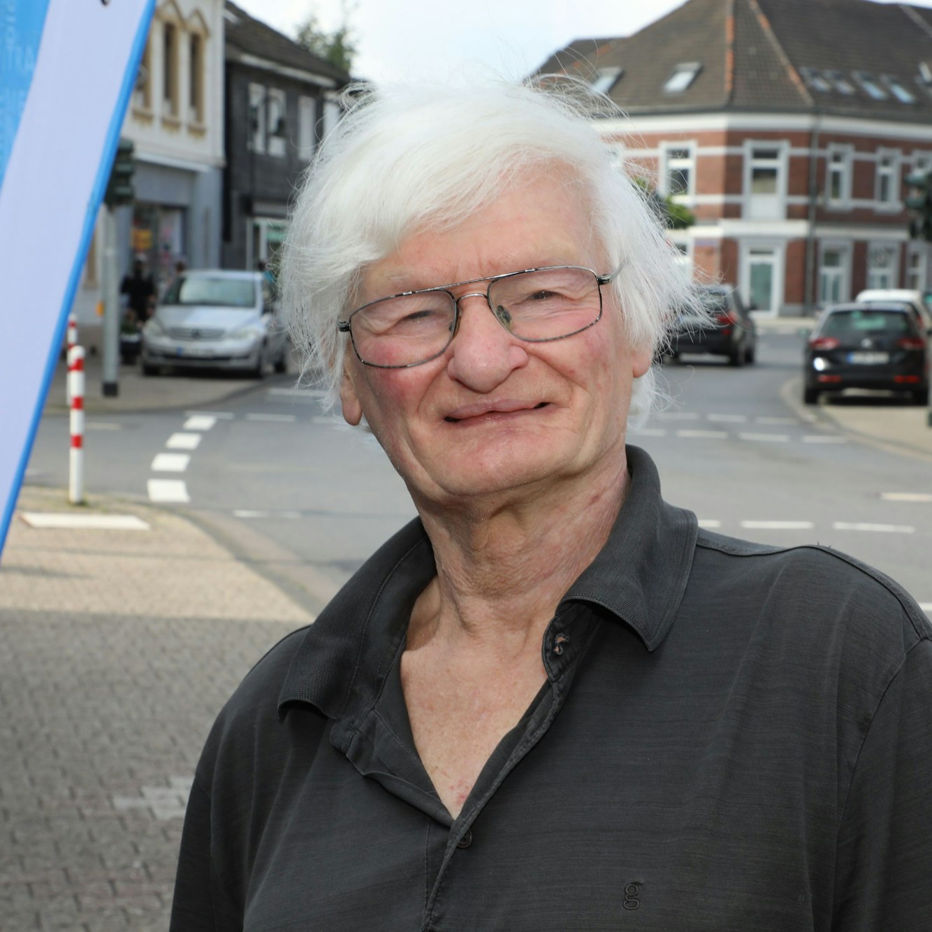 Jürgen Reusch lächelt an der Hauptstraße in Rösrath-Hoffnungsthal.