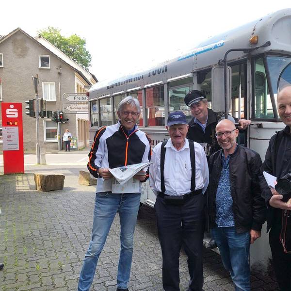 Menschen stehen an einem historischen amerikanischen Schulbus.