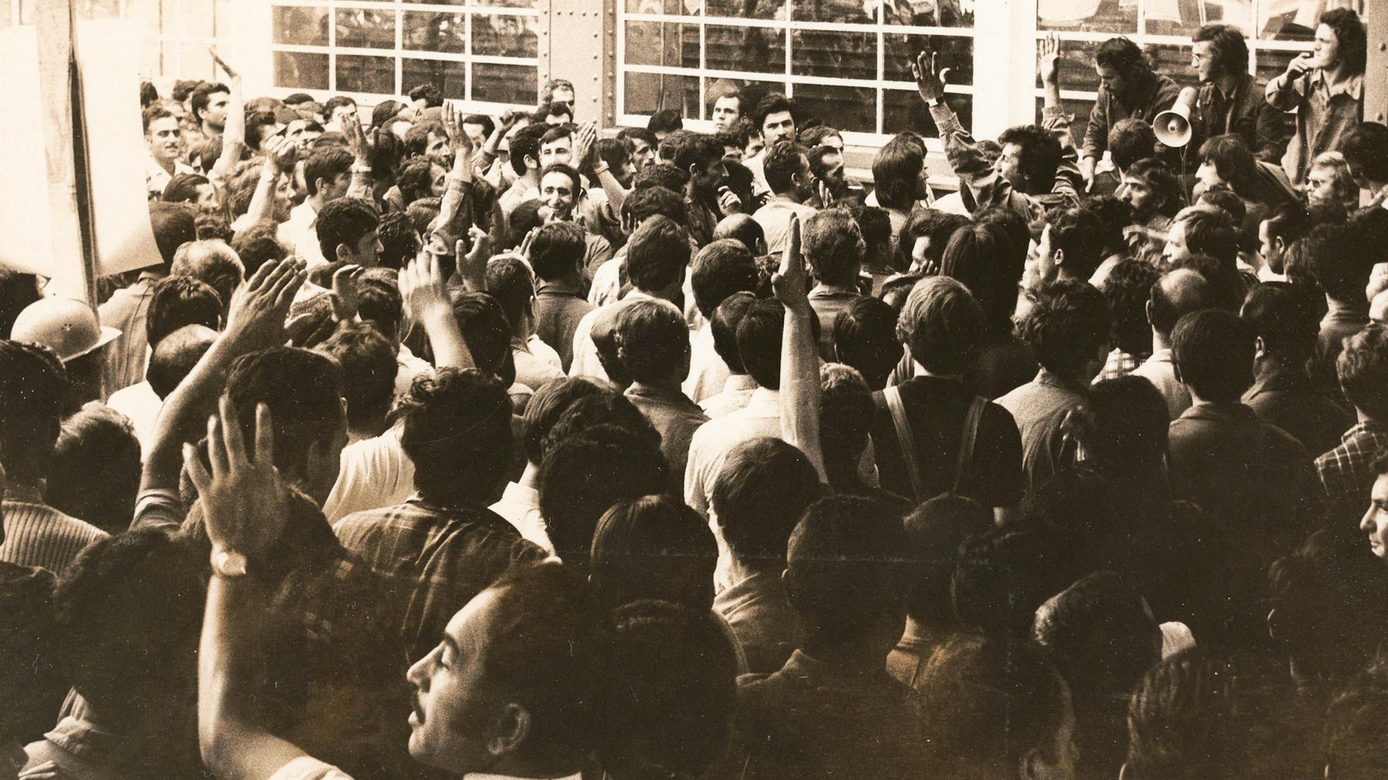 Mehrere Personen stehen in einem Pulk zusammen.