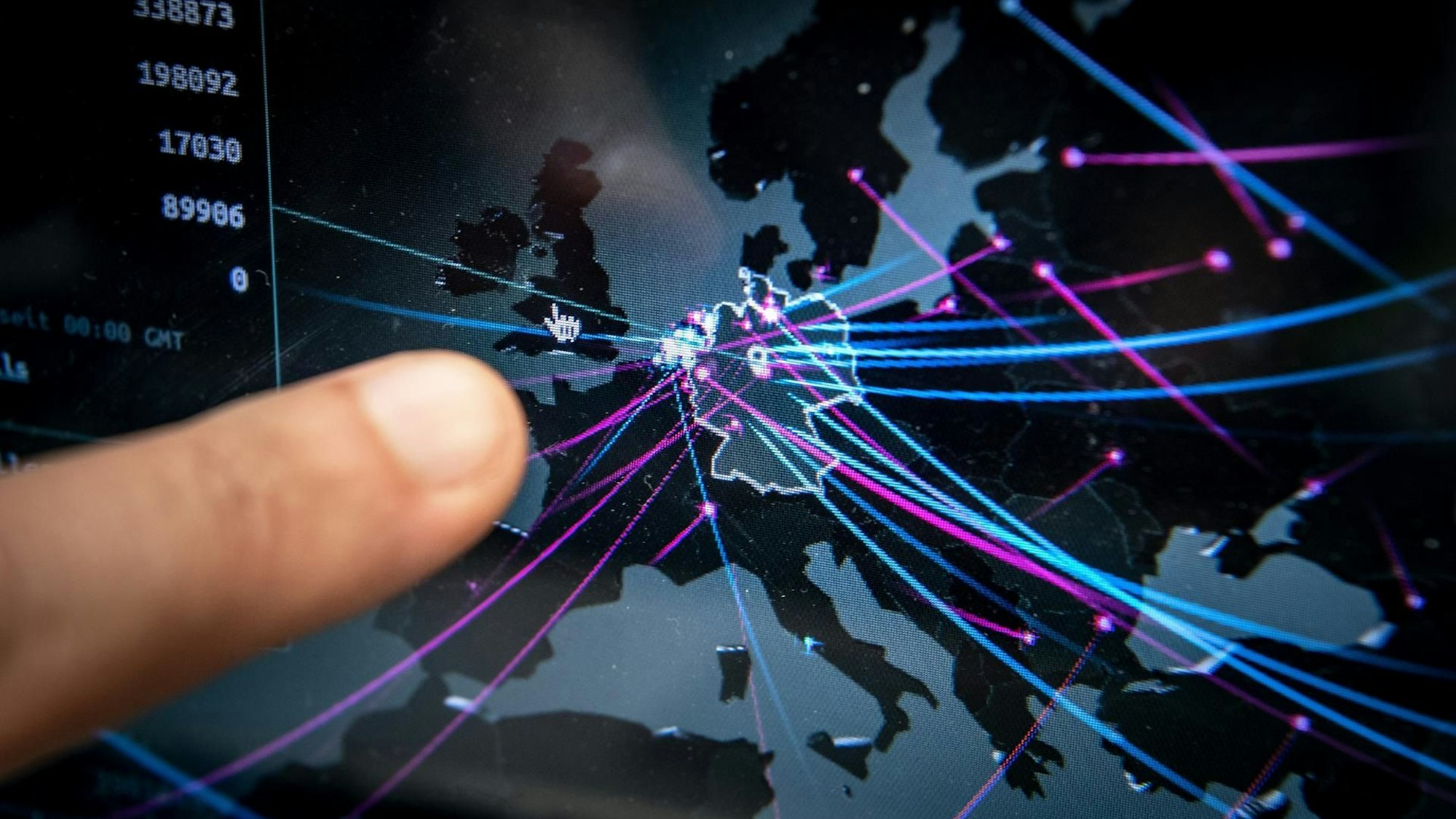 Ein Mitarbeiter der Polizei zeigt auf einer Echtzeitkarte von Kaspersky die Cyberbedrohung in Deutschland.