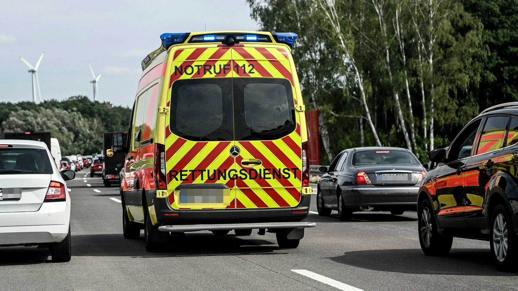 Ein Rettungswagen fährt durch eine Rettungsgasse auf der Autobahn.