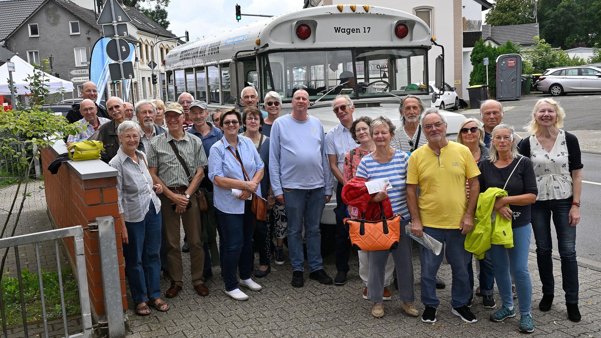 Menschen stehen vor einem historischen amerikanischen Schulbus.