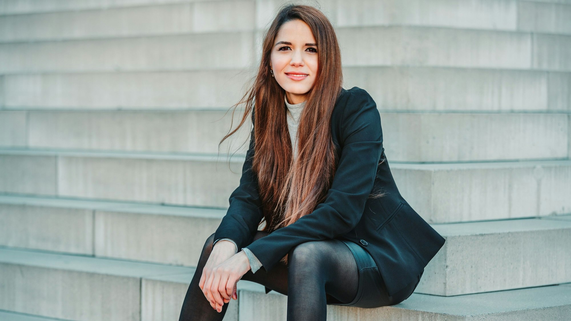 Fachärztin für Psychiatrie und Psychotherapie und Buchautorin Nasanin Kamani sitzt auf einer Treppe.