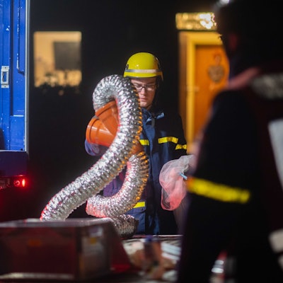 Ein THW-Mitarbeiter in Einsatzkleidung trägt silberfarbene Schläuche. Sie gehörten zu einer in Euskirchen entdeckten  Marihuana-Plantage.