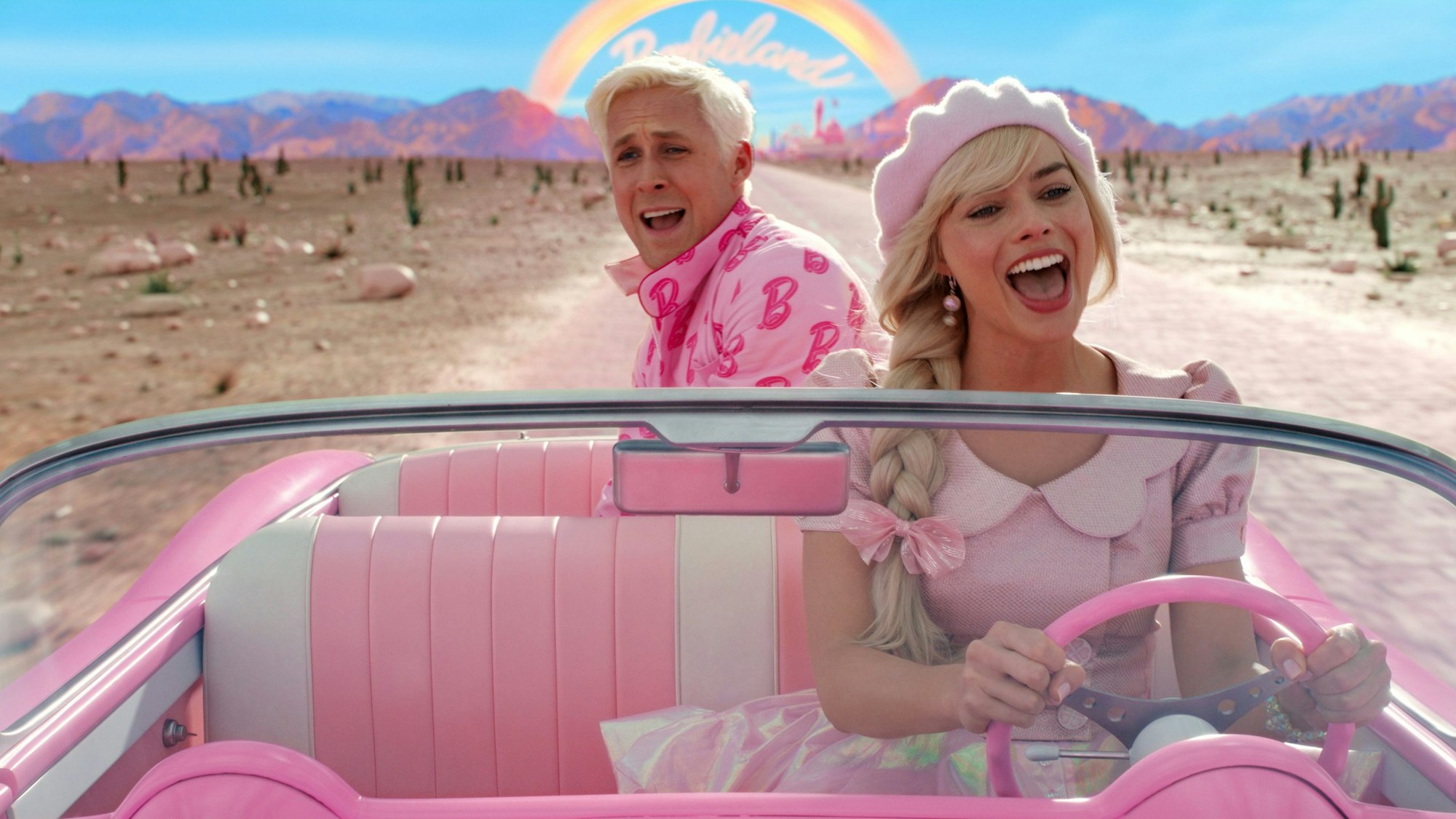 Ryan Gosling als Ken und Margot Robbie als Barbie singen in einem Auto in einer Szene der Films „Barbie“.