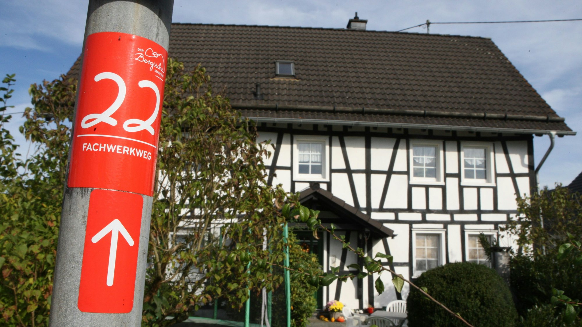 Ein Aufkleber mit dem Hinweis auf den Fachwerkweg, im Hintergrund ist ein Fachwerkhaus zu sehen.