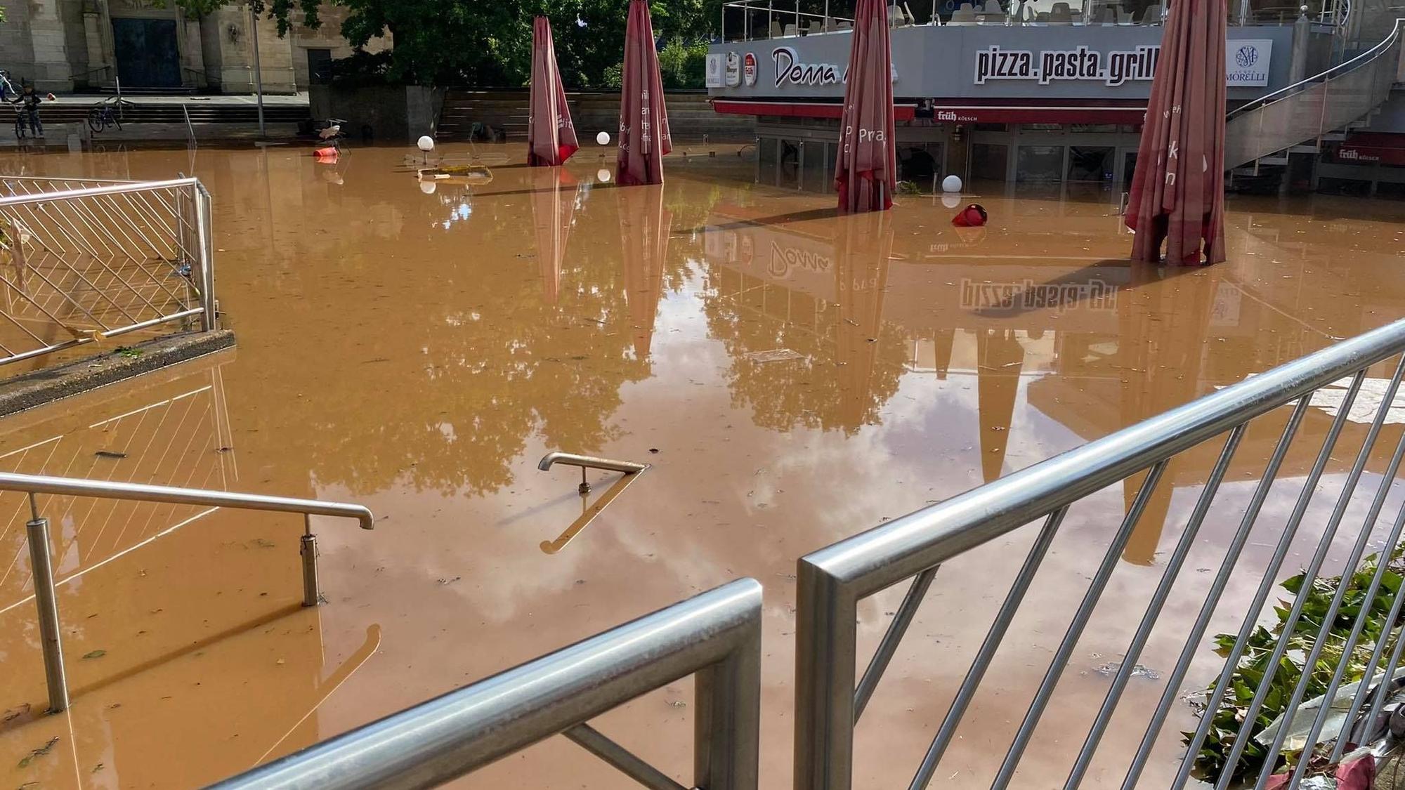 Das Bild zeigt den Herz-Jesu-Vorplatz nach der Flut. Das braune Wasser ist noch nicht abgeflossen.