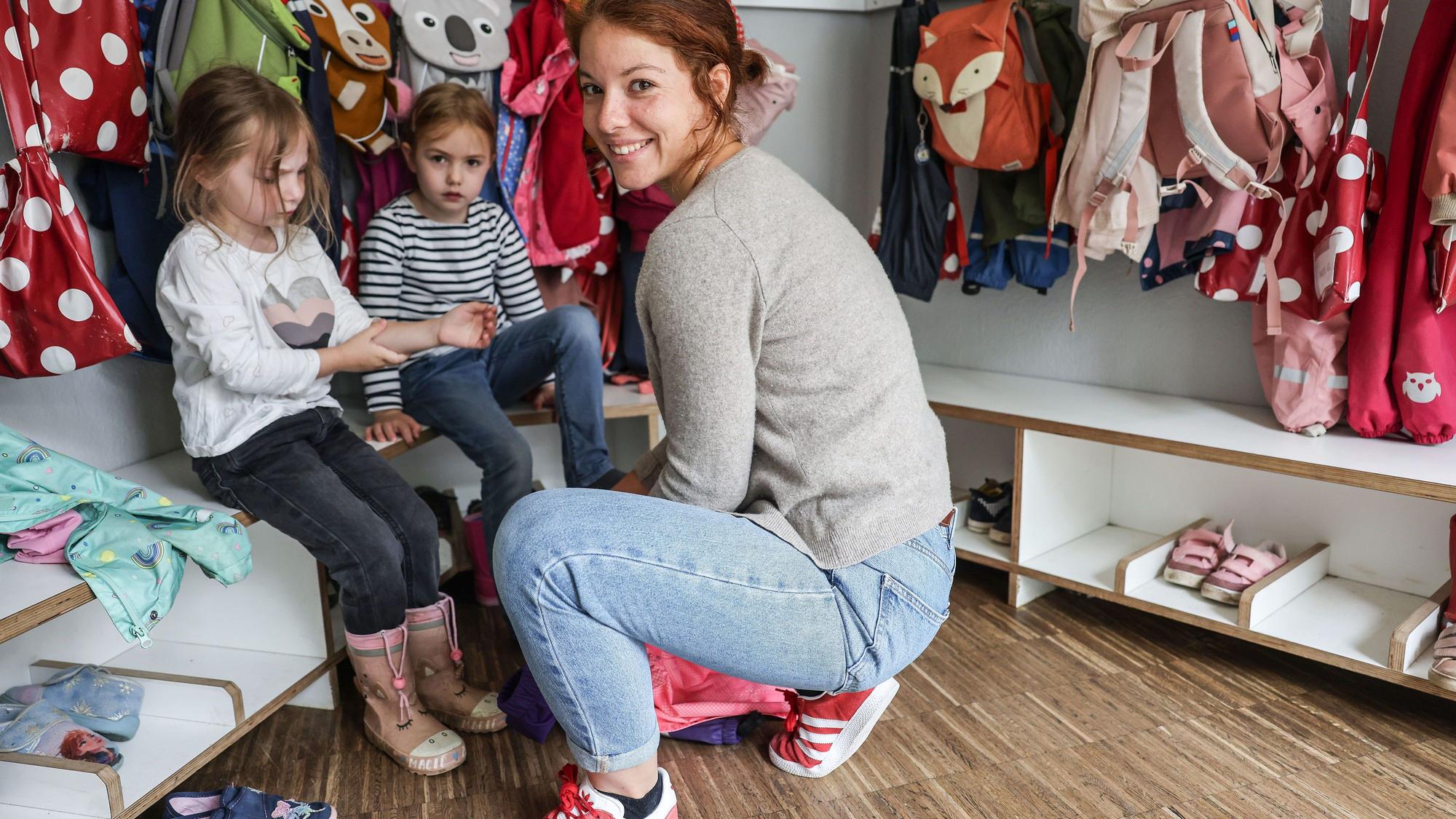 Anita Philipp hilft als Alltagshelferin in einer Kindertagesstätte Kindern beim Anziehen.