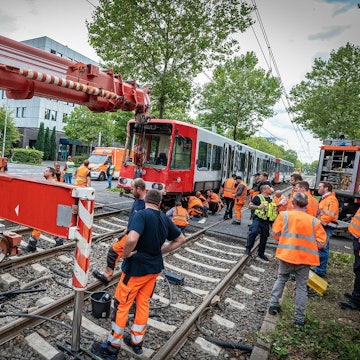 Der Bergekran der KVB hebt die Bahn zurück auf die Gleise.