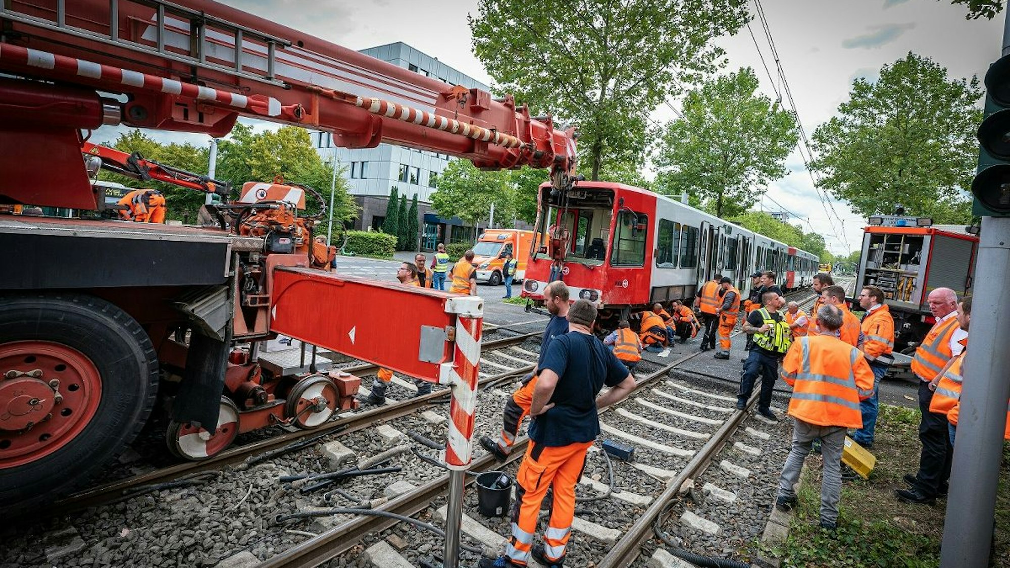 Der Bergekran der KVB hebt die Bahn zurück auf die Gleise.