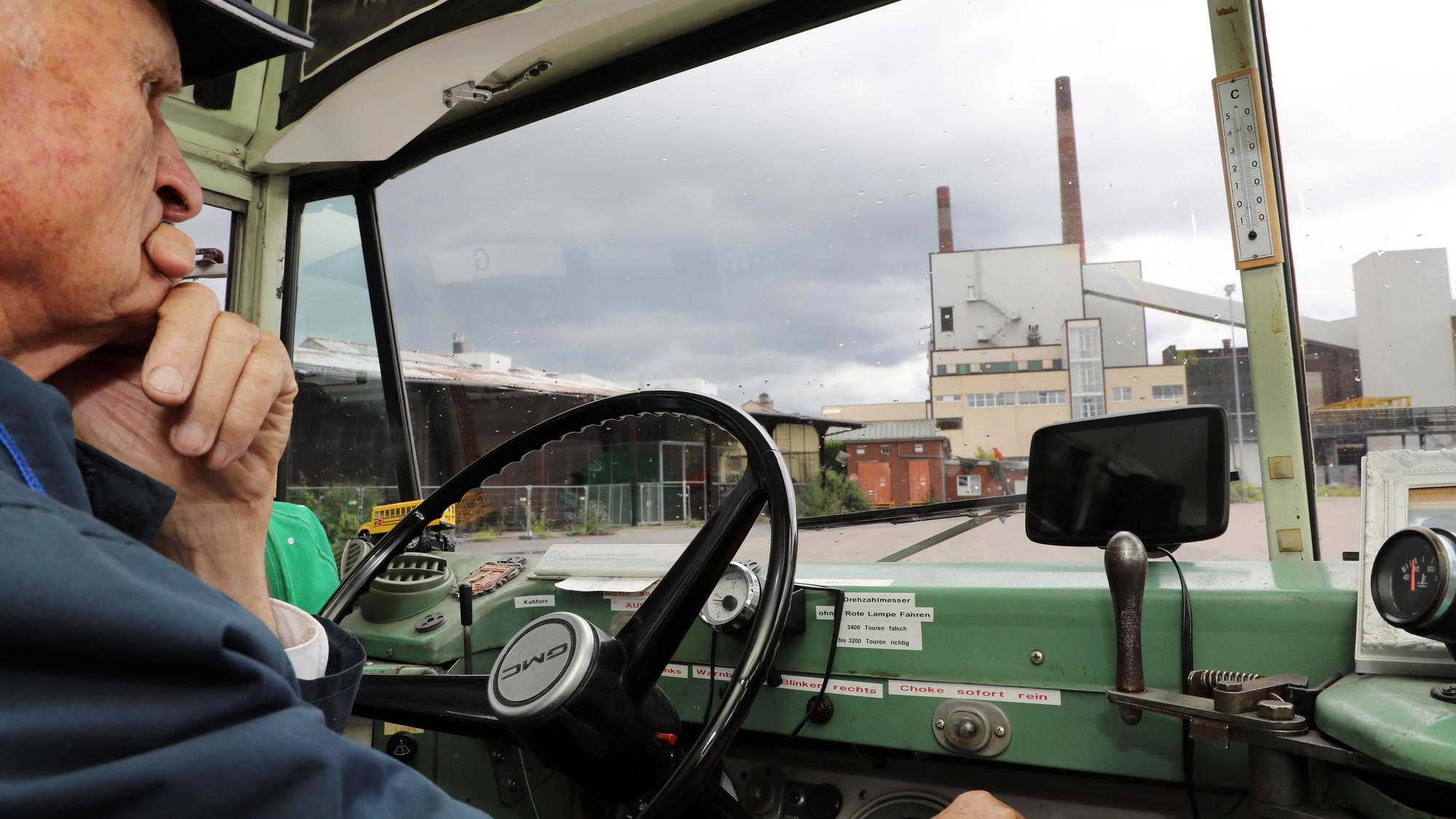 Ein Busfahrer fährt mit einem historischen Bus über das Zanders-Gelände in Bergisch Gladbach in Richtung des dortigen Kraftwerks.