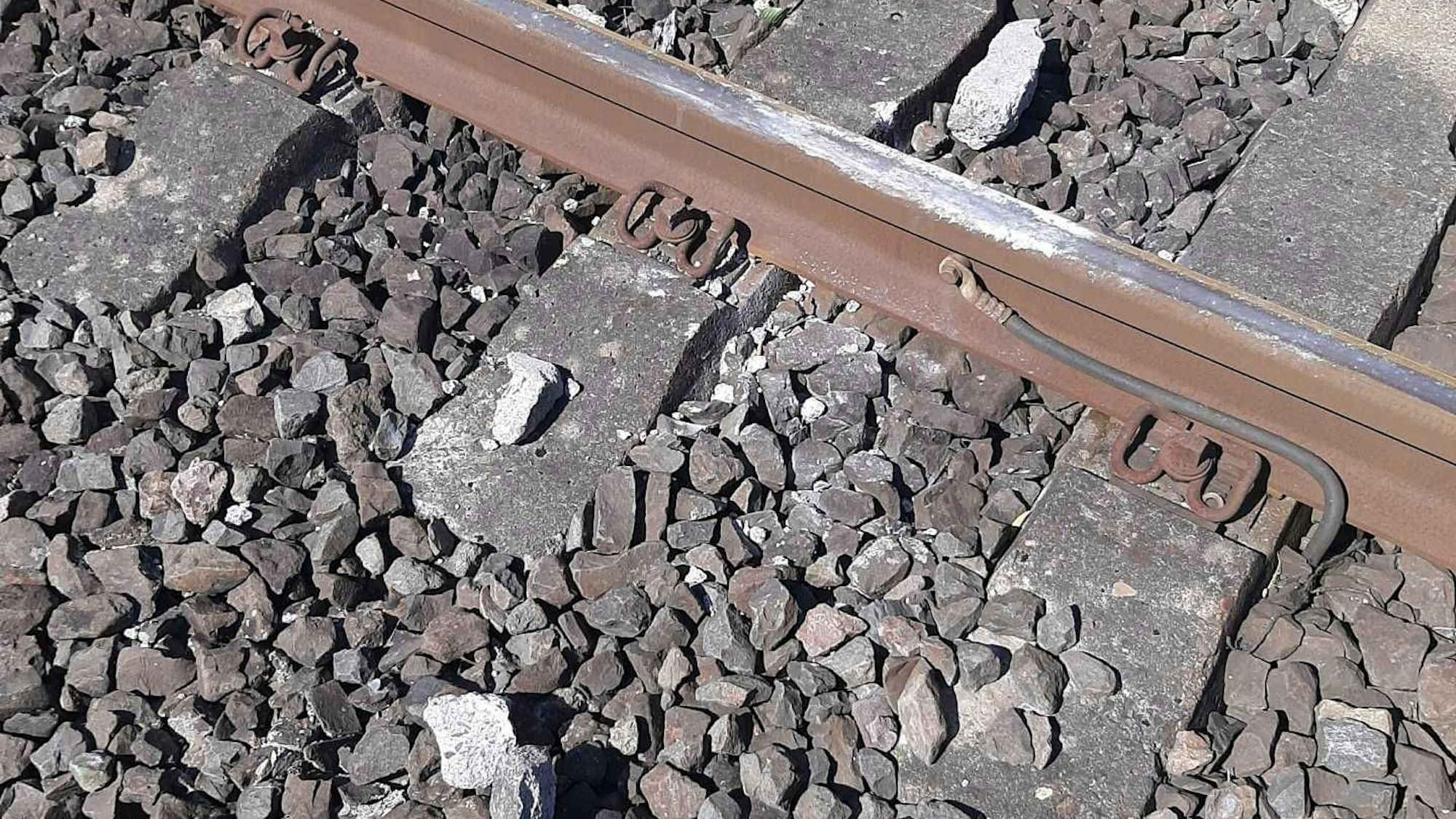 Rechts und links einer Schiene liegen die Trümmer eines Steins, der von einer S-Bahn überrollt wurde.