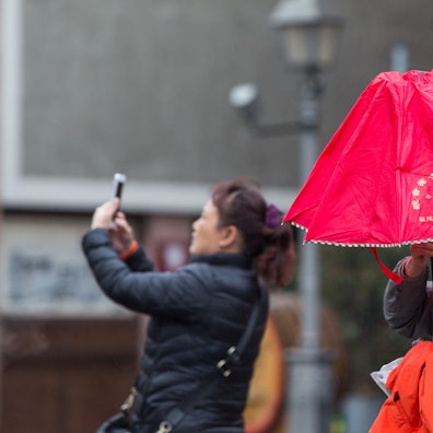 Eine Touristin steht mit ihrer chinesischen Reisegruppe auf dem Frankfurter Römerberg (Symbolbild).