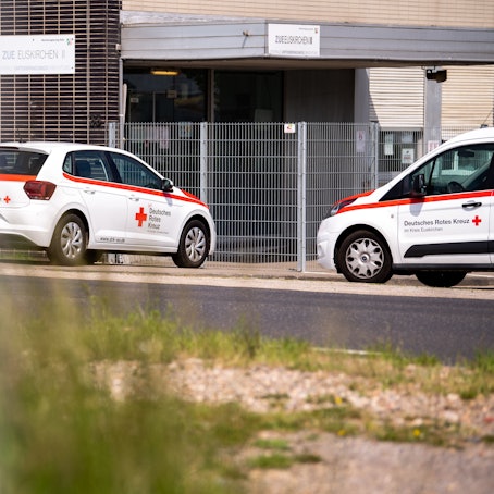 Vor der Geflüchtetenunterkunft in Euskirchen stehen zwei Fahrzeuge des DRK, das die Einrichtung betreibt.